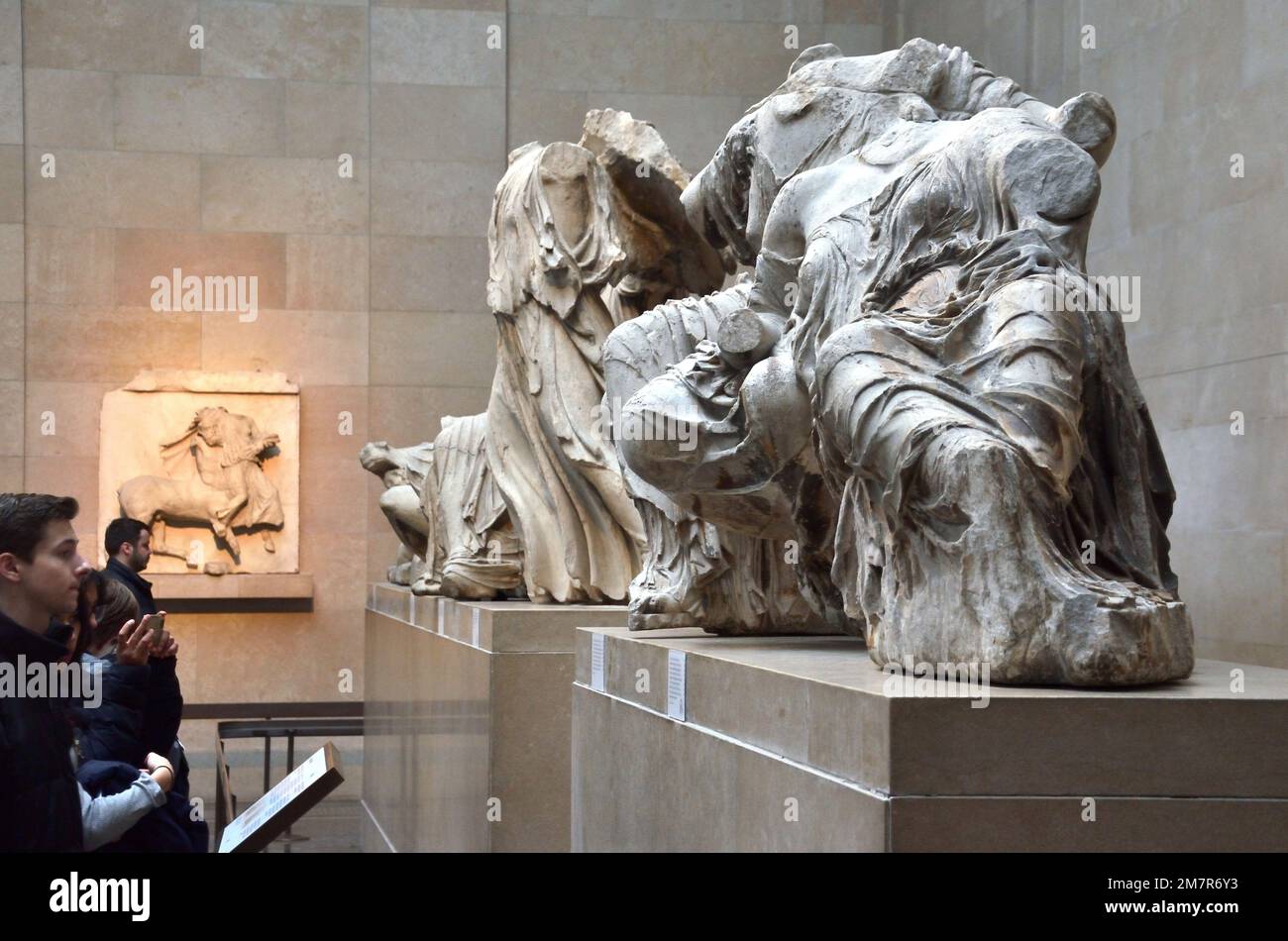 Visitors observing some of the ancient Parthenon Marble Sculptures at the British Museum in London, 2023. Stock Photo