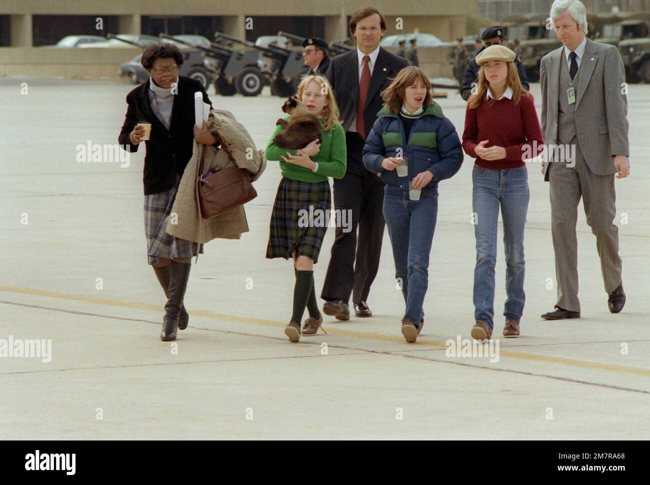 Amy Carter and her friends walk across the apron toward the aircraft that will carry her and her family back to Plains, Georgia, at the conclusion of President Ronald Reagan's inauguration ceremony. Base: Andrews Air Force Base State: Maryland (MD) Country: United States Of America (USA) Stock Photo