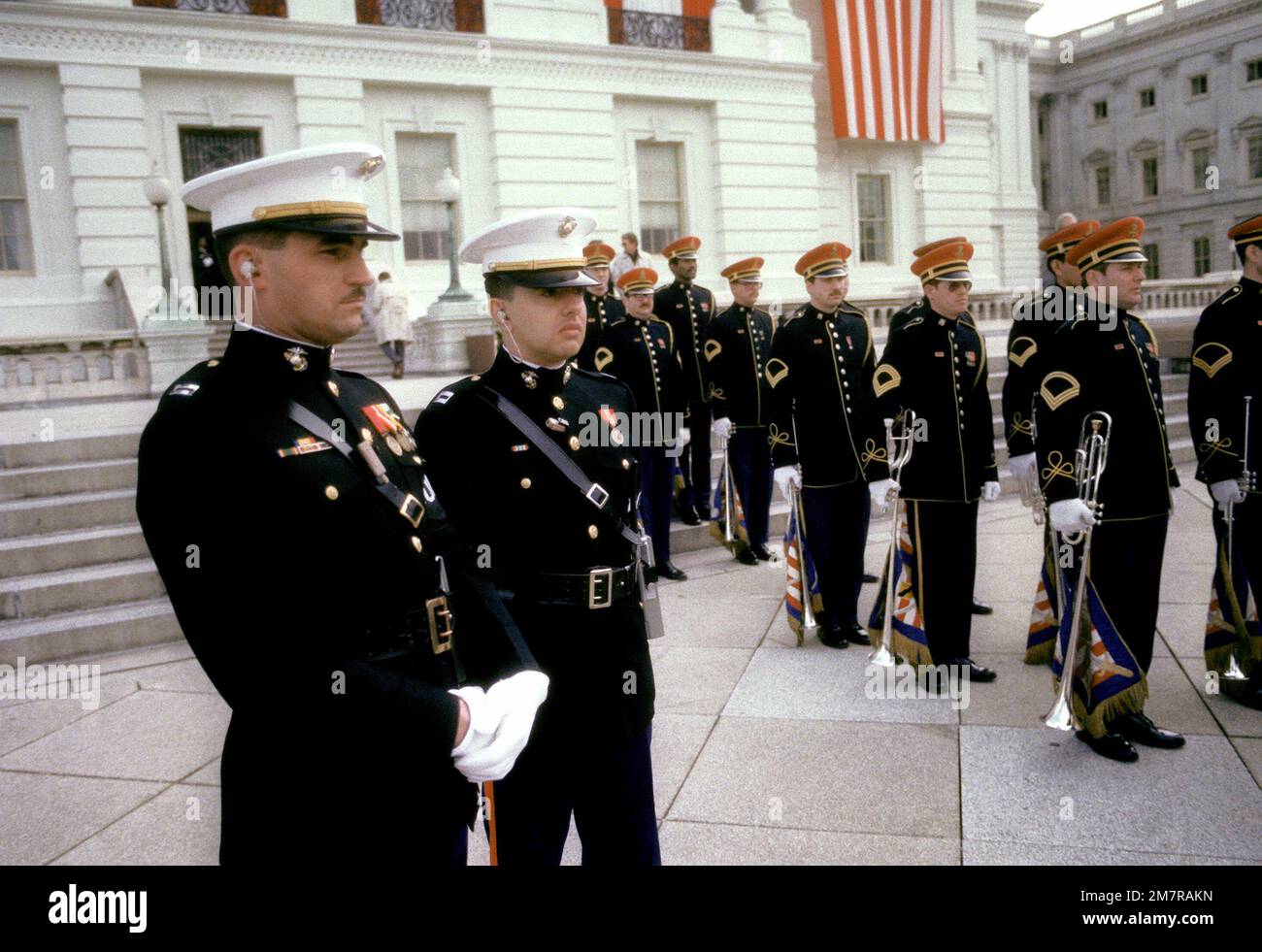 Two Marine Corps captains in full dress blues, wearing the famous Sam Brown belt, watch the U.S. Army Herald Trumpeters get into formation on Inauguration Day. Base: Washington State: District Of Columbia (DC) Country: United States Of America (USA) Stock Photo