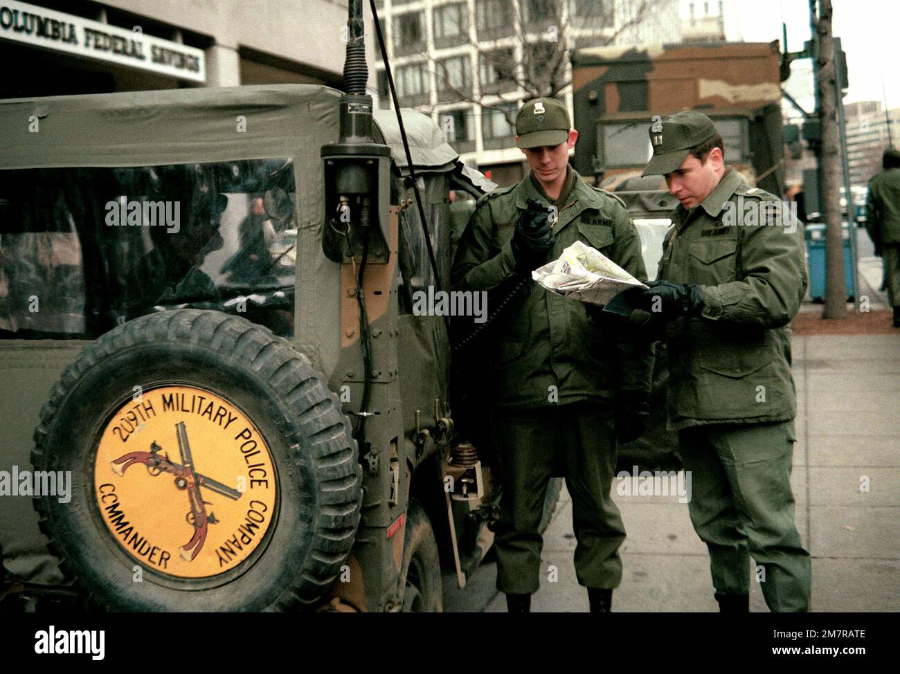 The commander of the 209th Military Police Company, an Army captain, stands next to his jeep and radio operator as he checks his street map during rehearsal for Inauguration Day. His radio operator is prepared to send a radio message. The 209th is located at Fort Meade, Md. Base: Washington State: District Of Columbia (DC) Country: United States Of America (USA) Stock Photo