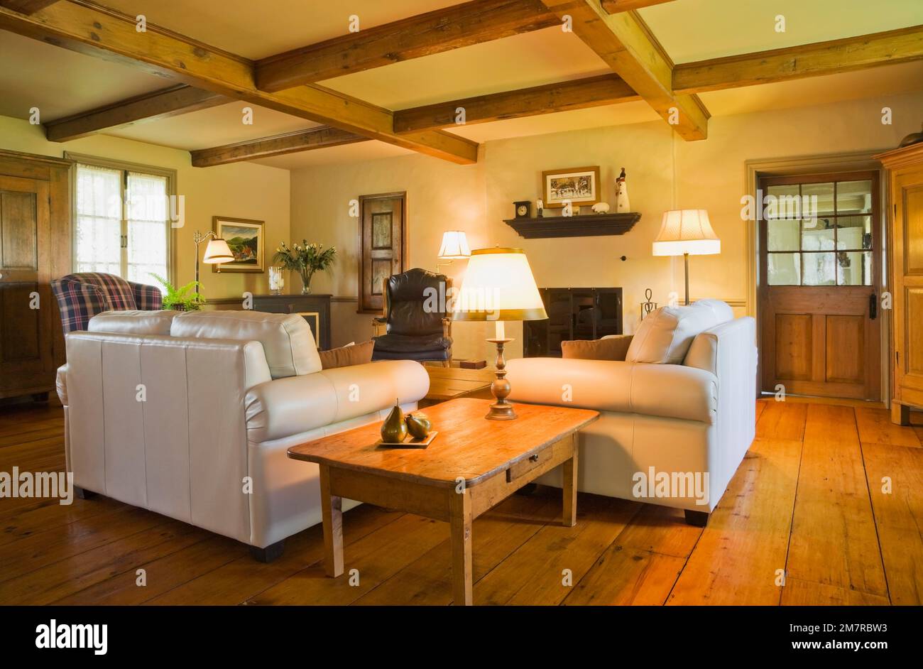 Antique wooden table and white leather sofas in living room inside old ...