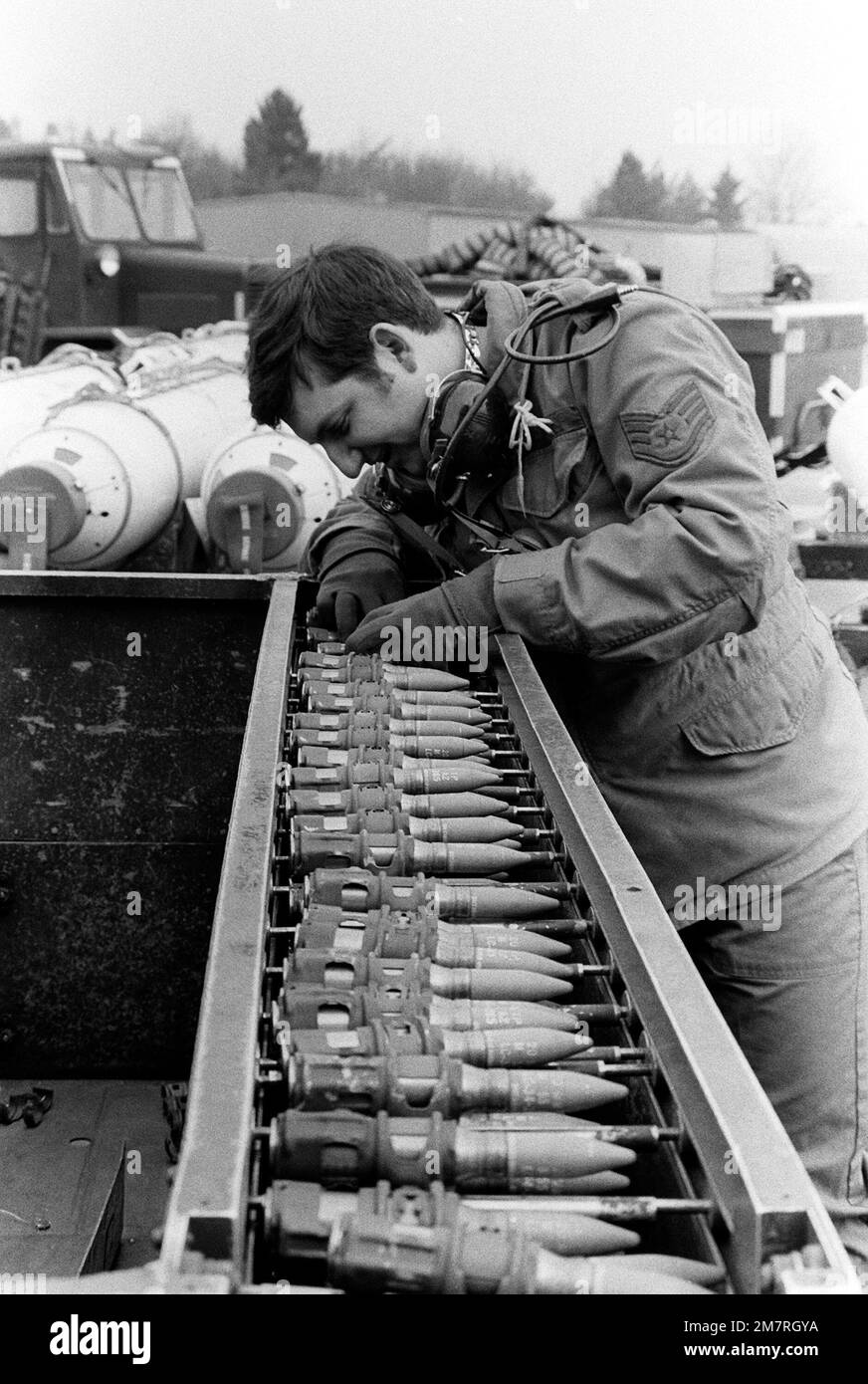 SSGT Ron Lowery checks a quick loader of 20mm rounds to ensure proper clipping. SSGT Lowery is a loading crew supervisor preparing to load the rounds into an F-4 Phantom II aircraft nose gun. Base: Spangdahlem Air Base State: Rheinland-Pfalz Country: Deutschland / Germany (DEU) Stock Photo