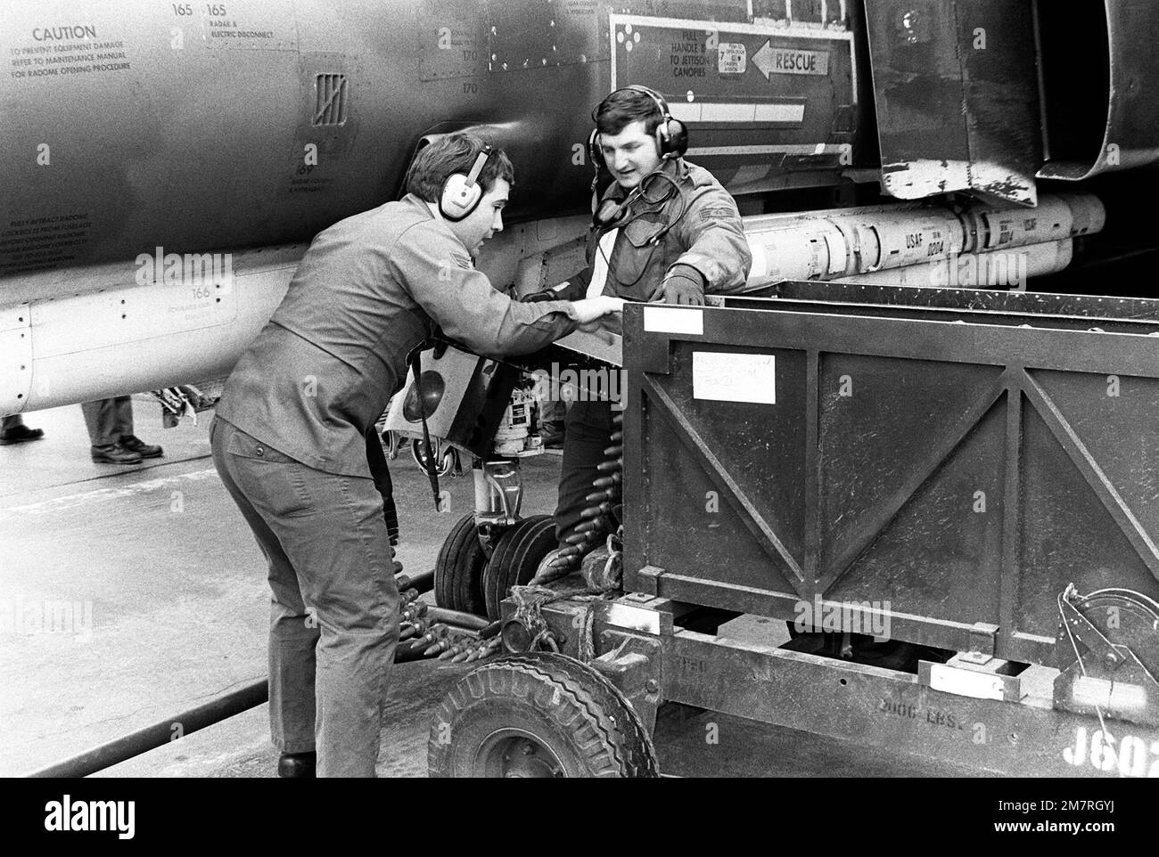 SGT Anderson and Loading Crew Supervisor, SSGT Ron Lowery, left to right, use a quick loader to load 20mm rounds into an F-4 Phantom II aircraft nose gun. Base: Spangdahlem Air Base State: Rheinland-Pfalz Country: Deutschland / Germany (DEU) Stock Photo