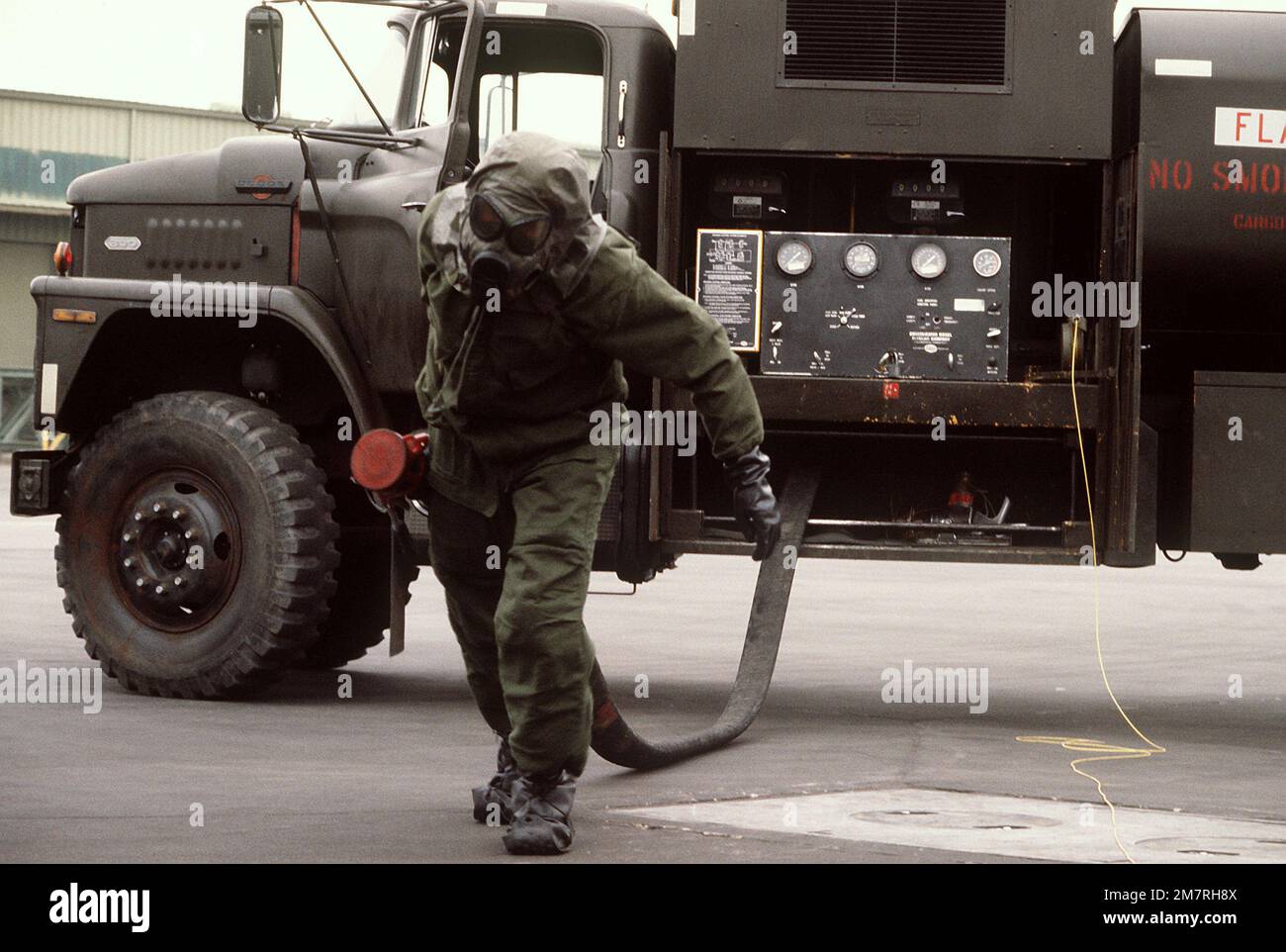 A ground crewman wearing protective clothing for a chemical warfare