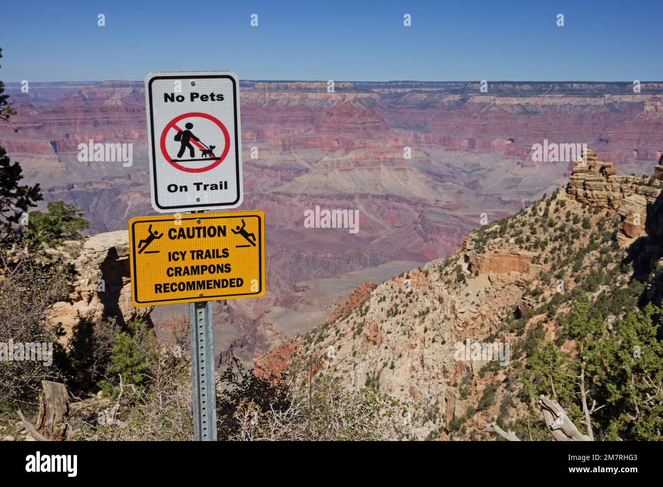 Grand Canyon warning signs no pets on trail and caution icy trails crampons recommended near the top of the South Kaibab Trail Stock Photo