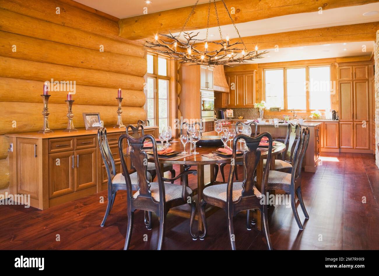Round wooden dining room table with 8 chairs and kitchen inside luxurious  Scandinavian style log home, Quebec, Canada. This image is property  released Stock Photo - Alamy