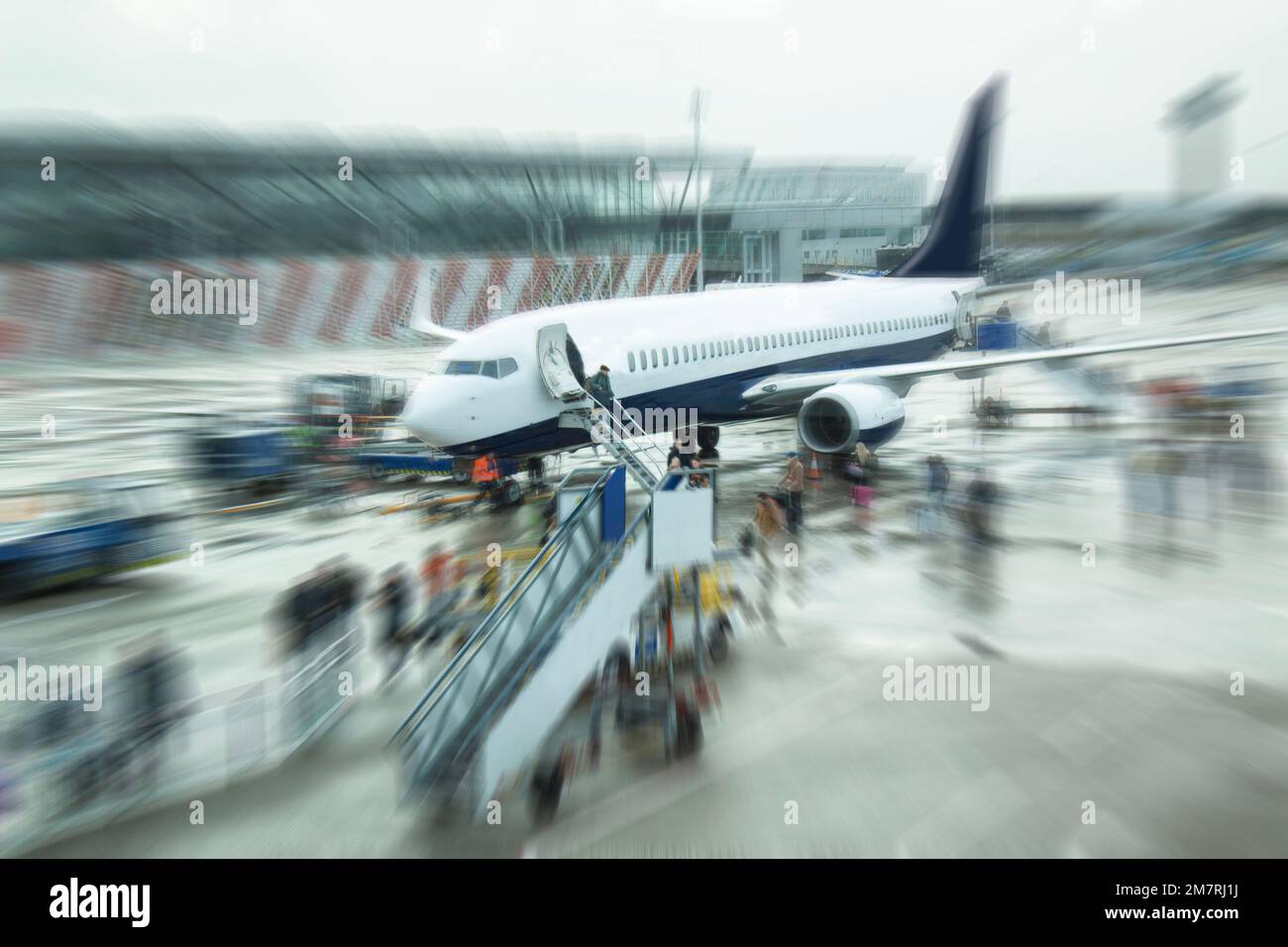 Passengers and workers at unidentified airplane. Blurred zoom image. Stock Photo