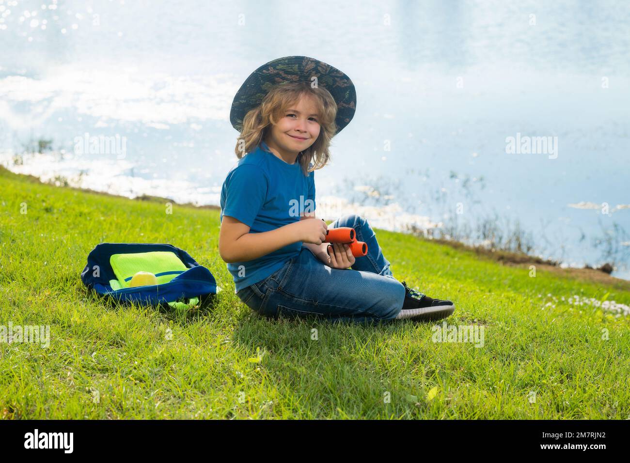 Scout boy wearing explorer hat and backpack outdoor. Explorer and adventure with binocular. Stock Photo