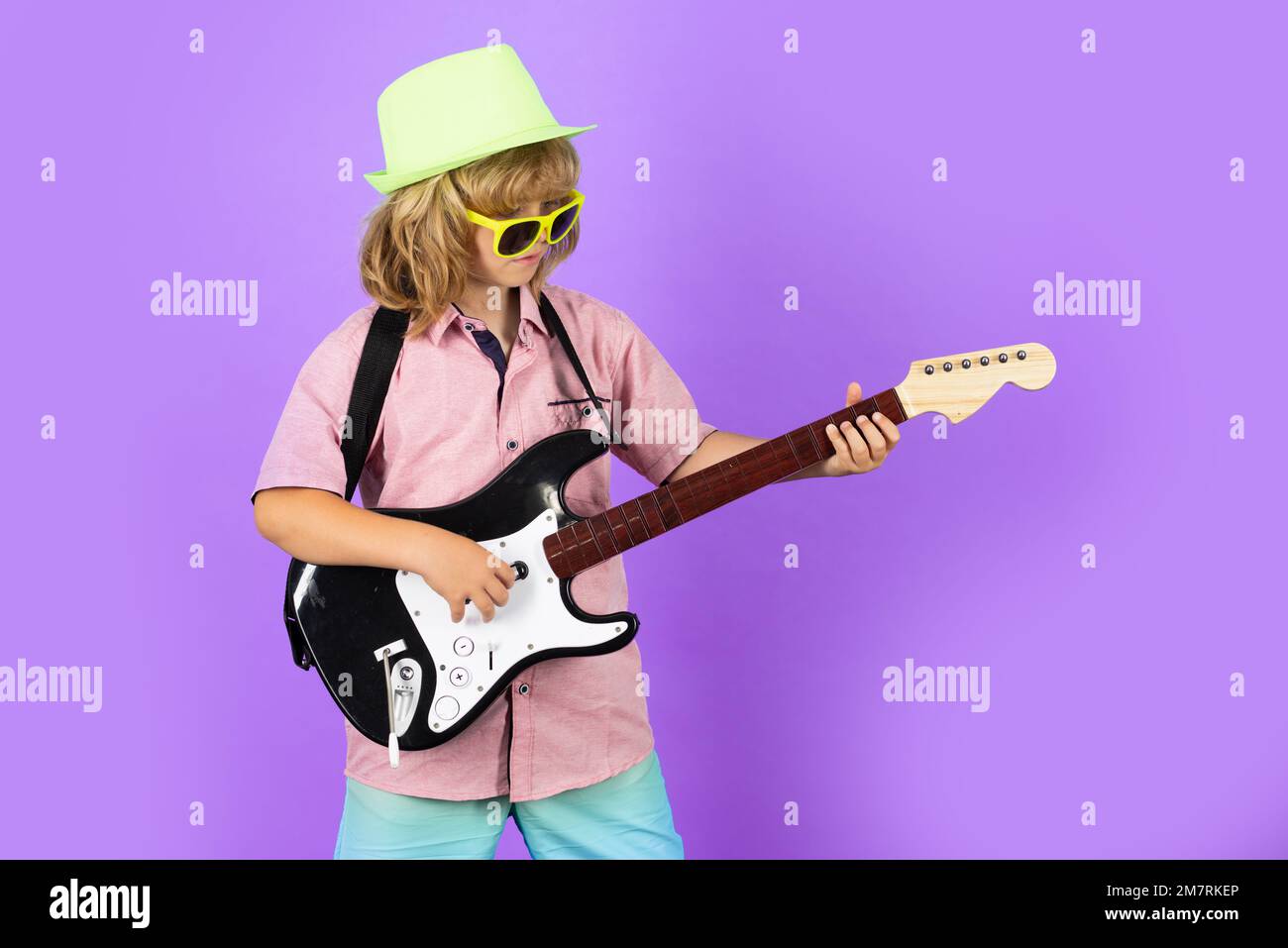 Fashion American country boy playing music. Kid boy playing guitar
