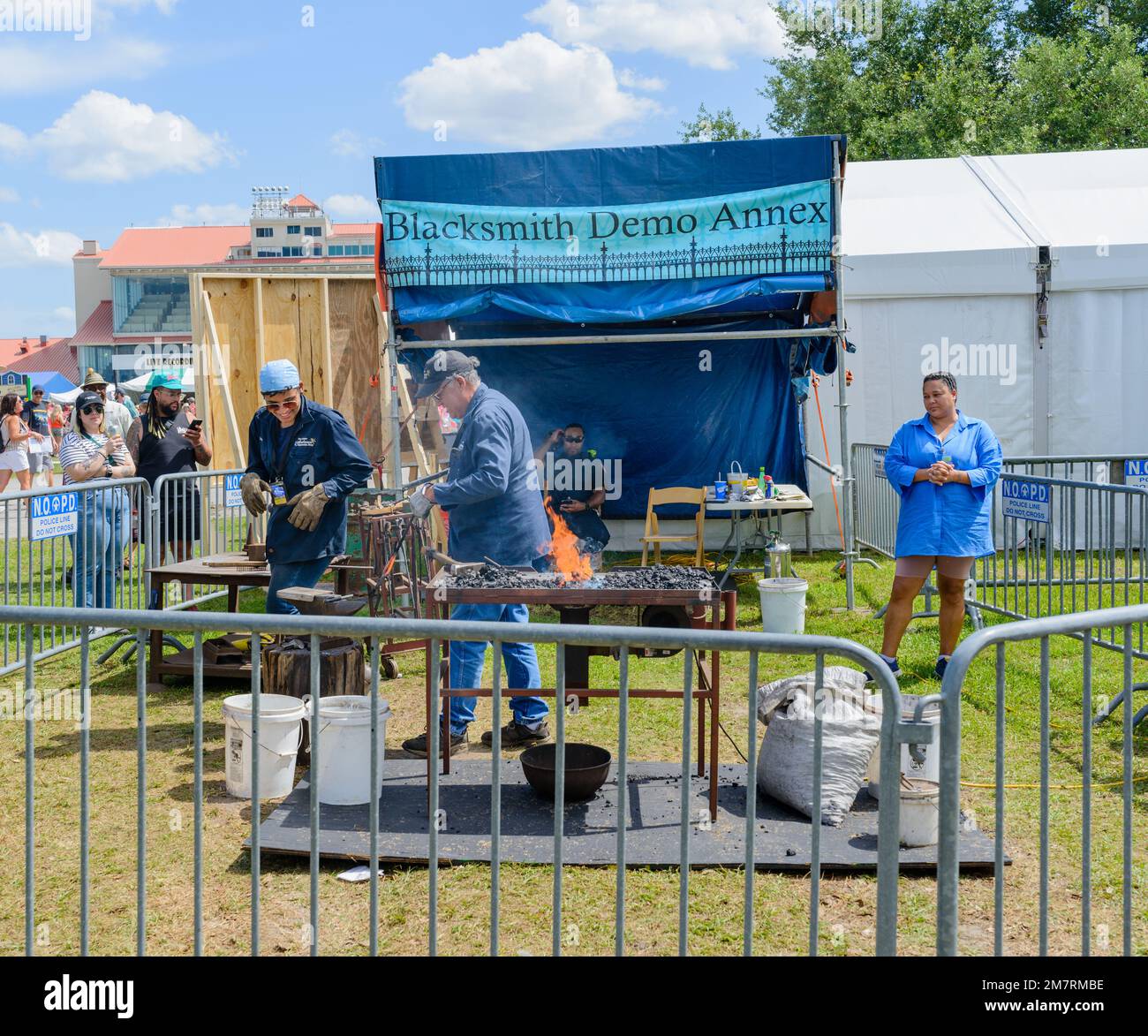 NEW ORLEANS, LA, USA - APRIL 29, 2022: Blacksmith moves fired metal tool to anvil for shaping at the New Orleans Jazz and Heritage Festival Stock Photo