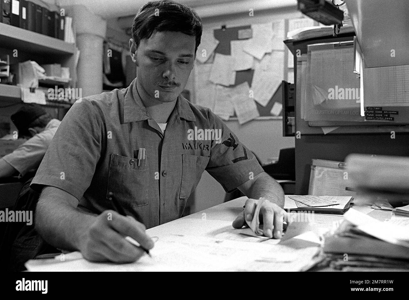 PO3 Kaikar does administrative work aboard the destroyer USS JOHN