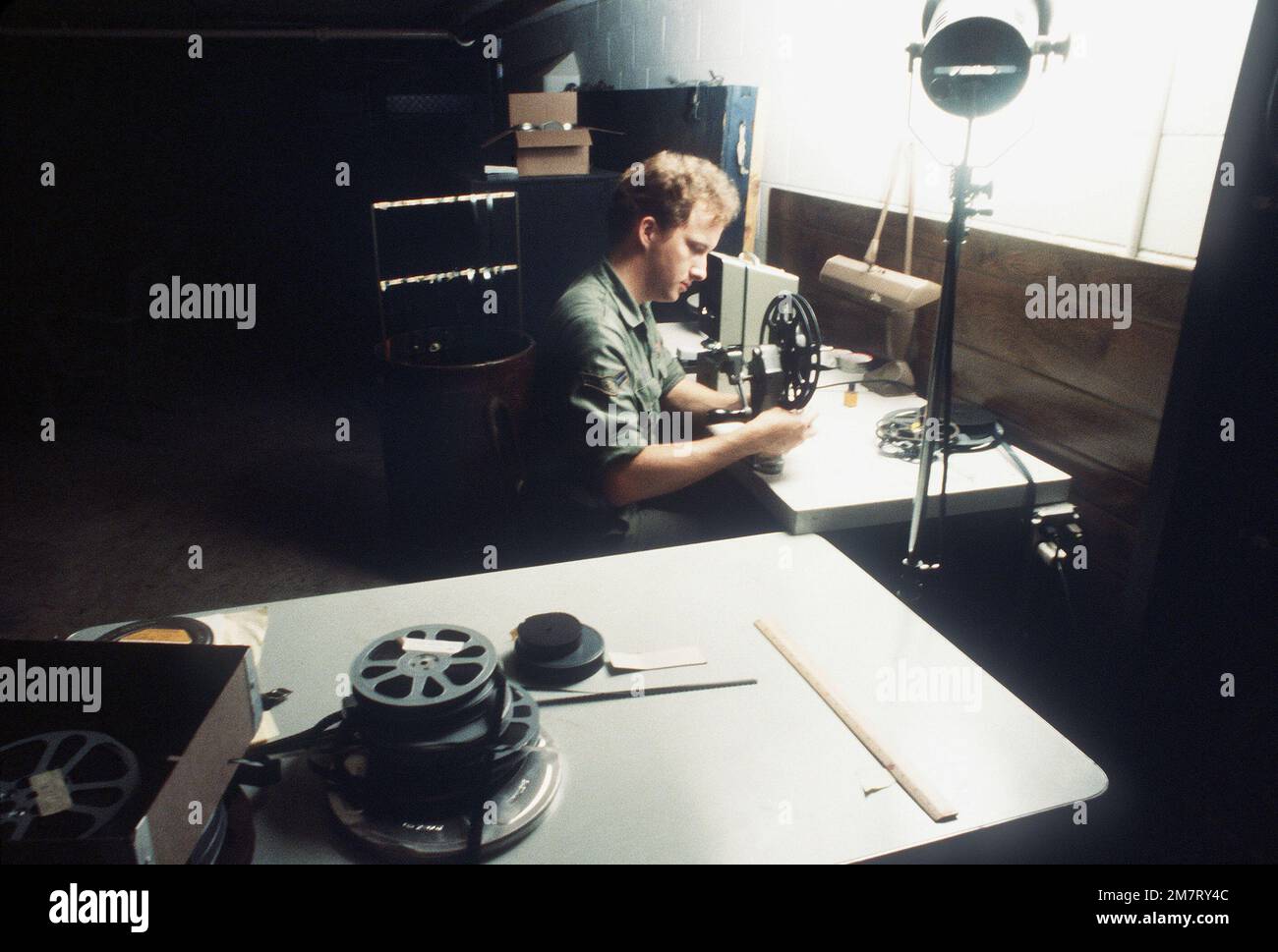 A1C Thomas F. Donahoe splices and edits 16mm film in the editing room, during a mission briefing for the 1361st Audio Visual Squadron, Detachment Seven. Base: Charleston Air Force Base State: South Carolina (SC) Country: United States Of America (USA) Stock Photo