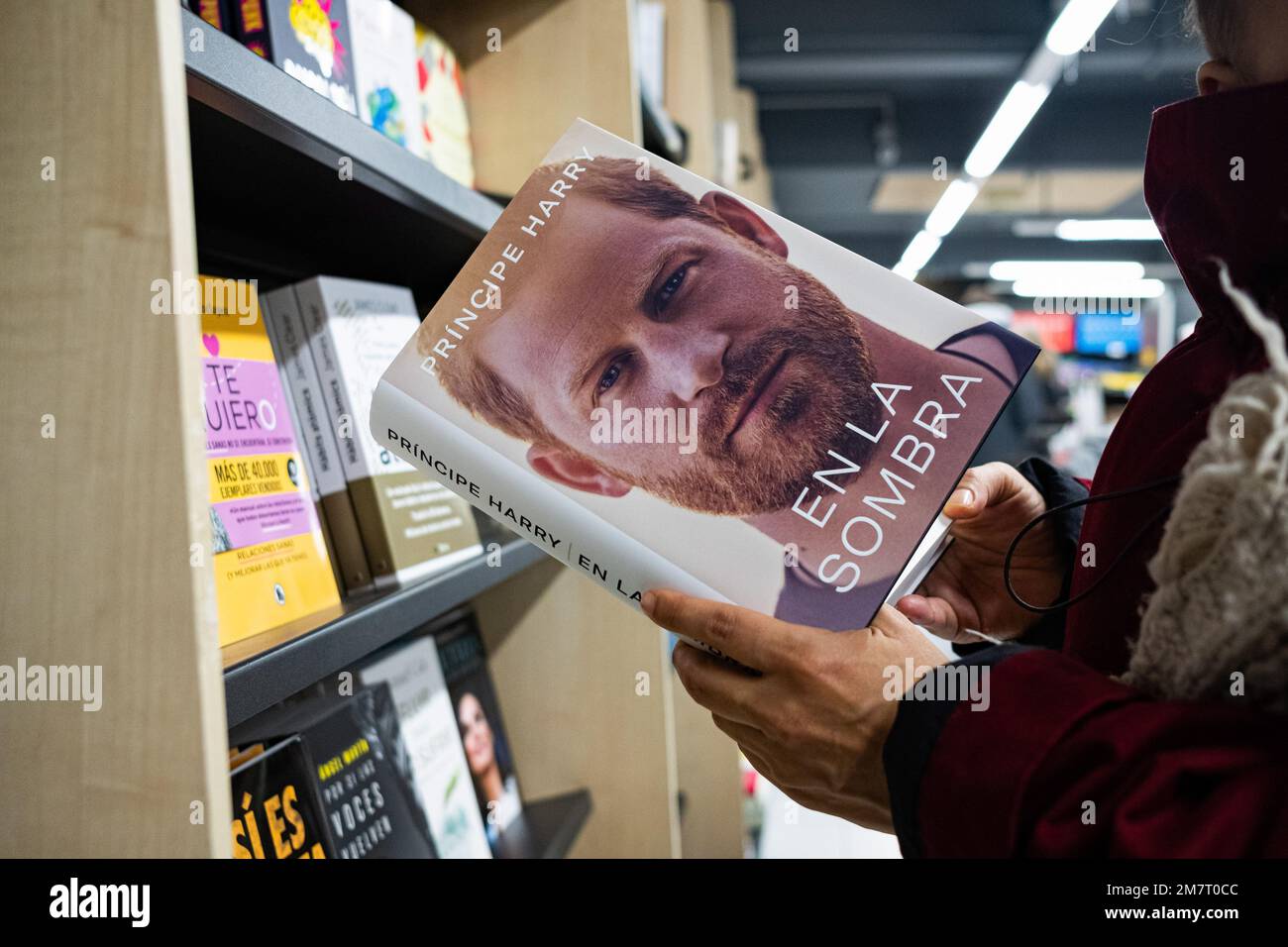 Barcelona, Spain. 10th Jan, 2023. A woman is seen holding the spanish edition of Prince Harry's memoir book, entitled 'En la Sombra', original title 'Spare', inside an 'Abacus' bookstore in the city center. Credit: SOPA Images Limited/Alamy Live News Stock Photo