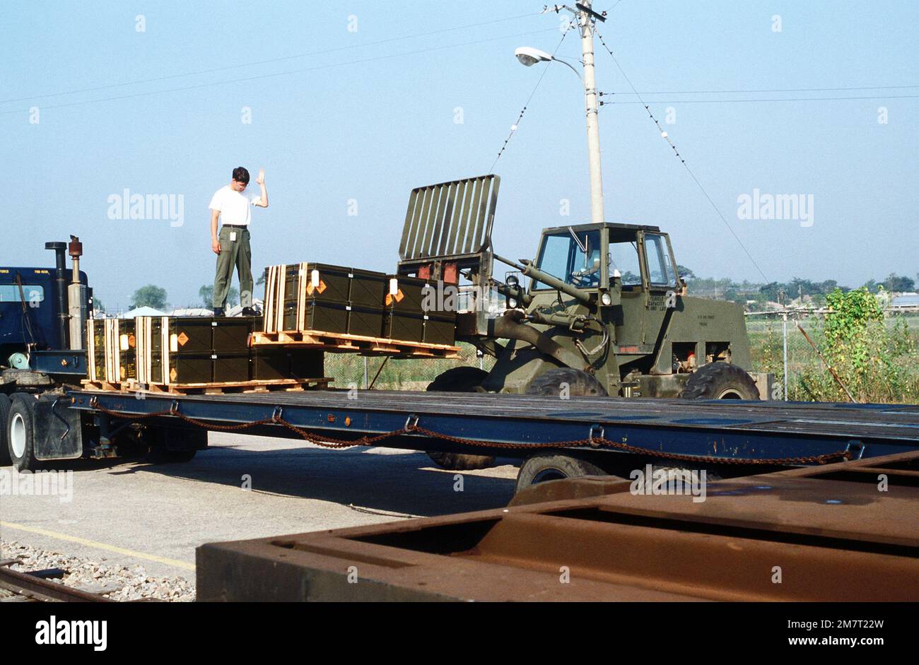 Cargo is unloaded from an Army trailer for reloading onto a flatbed ...