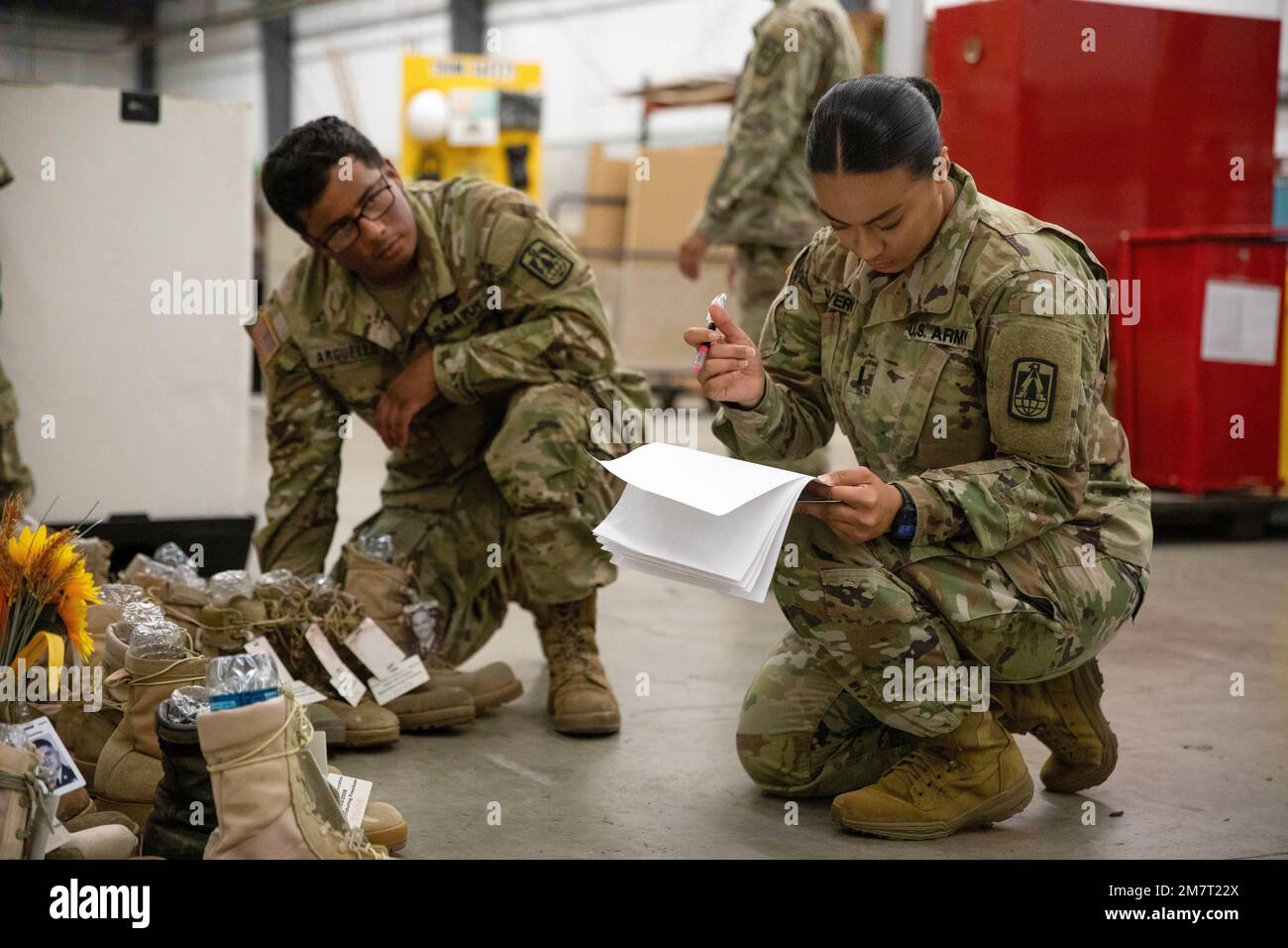 1st Lt. Andrea Viveros and Staff Sgt. Luz Arguello, Headquarters and Headquarters Company, 11th Signal Brigade, verify sorted boots while volunteering May 12, 2022, at Fort Hood, Texas, in preparation for the Memorial Remembrance Boot Display. This year marks the eighth annual display honoring those who gave the ultimate sacrifice. Each fallen Fort Hood service member is represented with a combat boot featuring the service member's name and photo, alongside an American flag. Stock Photo