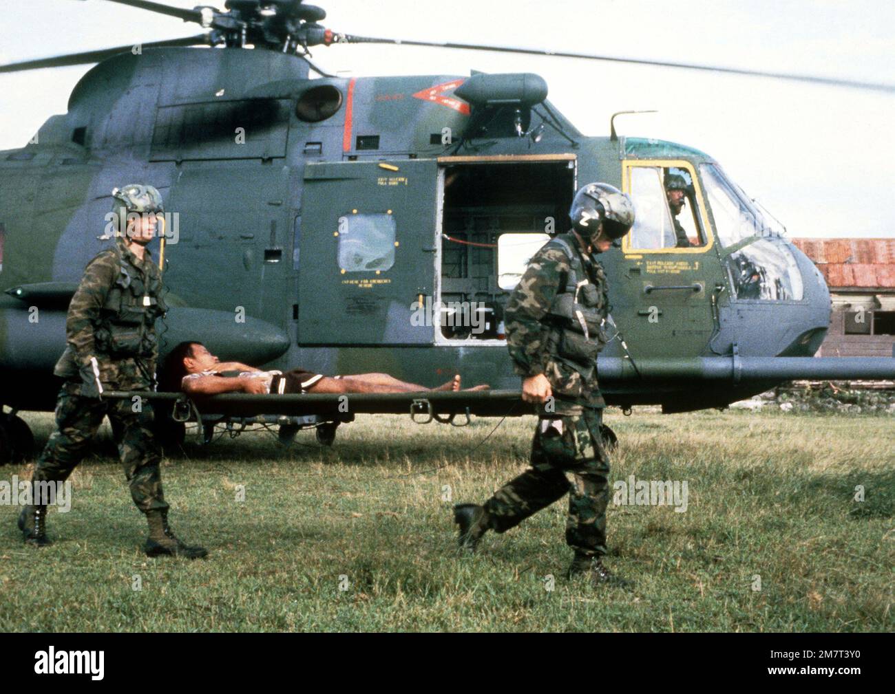 Pararescue members from the Military Airlift Command's Aerospace Rescue and Recovery Service carry an injured seaman who survived the capsized of the Philippines destroyer escort Datu Kalantiaw, to a treatment center after his evacuation aboard a CH-3 Sea King helicopter. Country: Philippines (PHL) Stock Photo