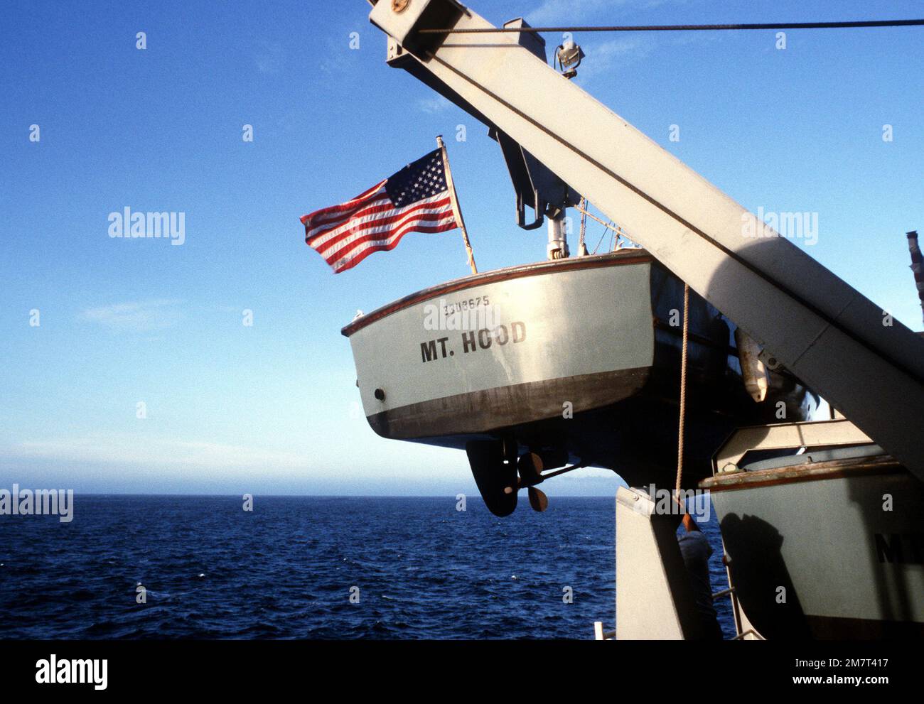 Preparations are made to lower a small boat over the side of the ammunition ship USS MOUNT HOOD (AE-29). The HOOD is assisting in rescue operations for the survivors of the capsized Philippine destroyer DATU KALANTIAW (ex-USS BOOTH DE-170). Country: Philippine Sea Stock Photo