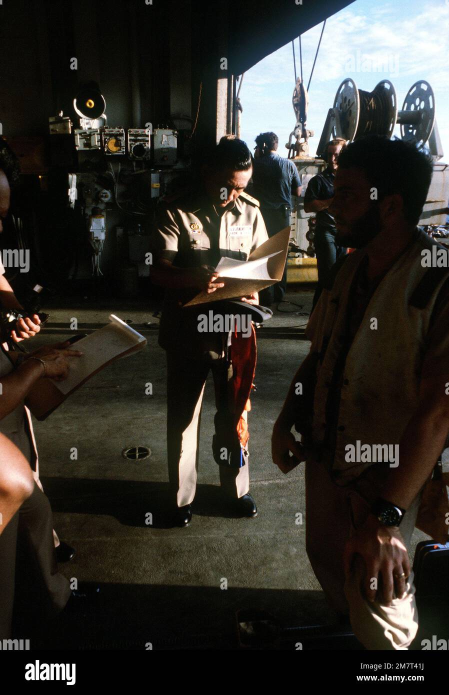 RADM Simeon Alejandro, flag officer in command of the Philippine Navy, aboard the ammunition ship USS MOUNT HOOD (AE-29), looks at some of the paper work dealing with the rescue operations for the survivors of the Philippine destroyer DATU KALANTIAW (ex-USS BOOTH DE-170). Country: Philippine Sea Stock Photo