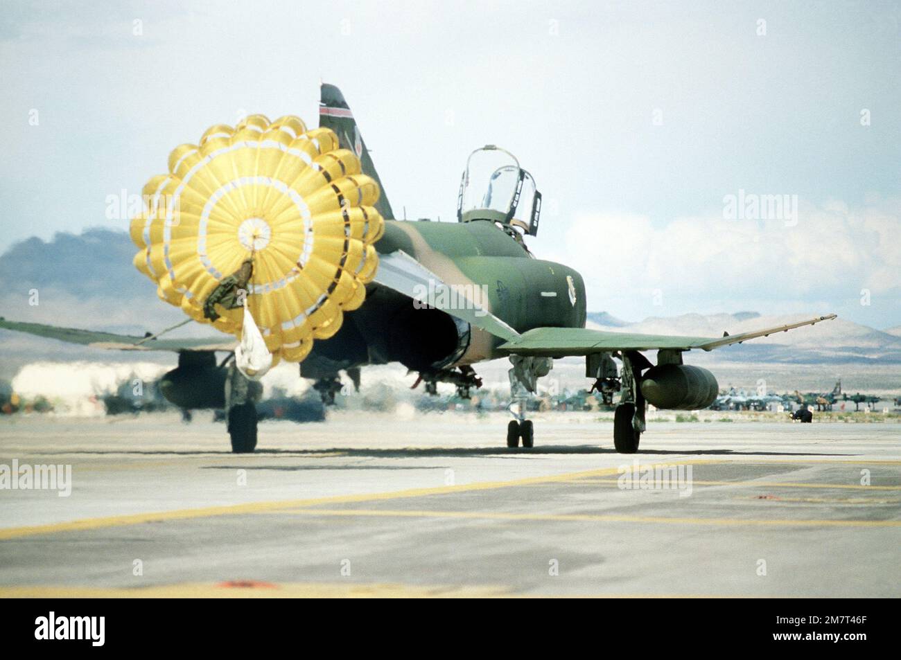 A right rear view of an F4 Phantom II aircraft as its drag chute is released upon landing