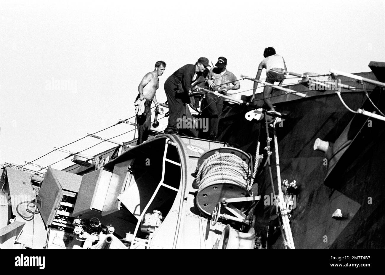 Crewmen from the ammunition ship USS MOUNT HOOD (AE-19) participate in search and rescue (SAR) operations aboard the beached and overturned Filipino frigate RPS DATU KALANTIAW (PS-76). The ship was overtaken by Typhoon Clara. Base: Calayan Island Country: Philippines Stock Photo