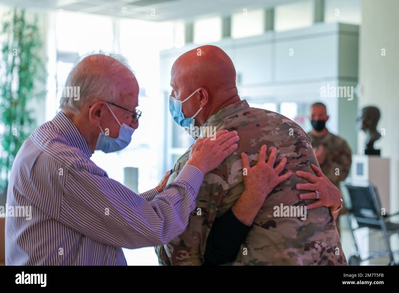 Command Sgt. Maj. Joshua Brown hugs nurses Jackie Brames while Dr