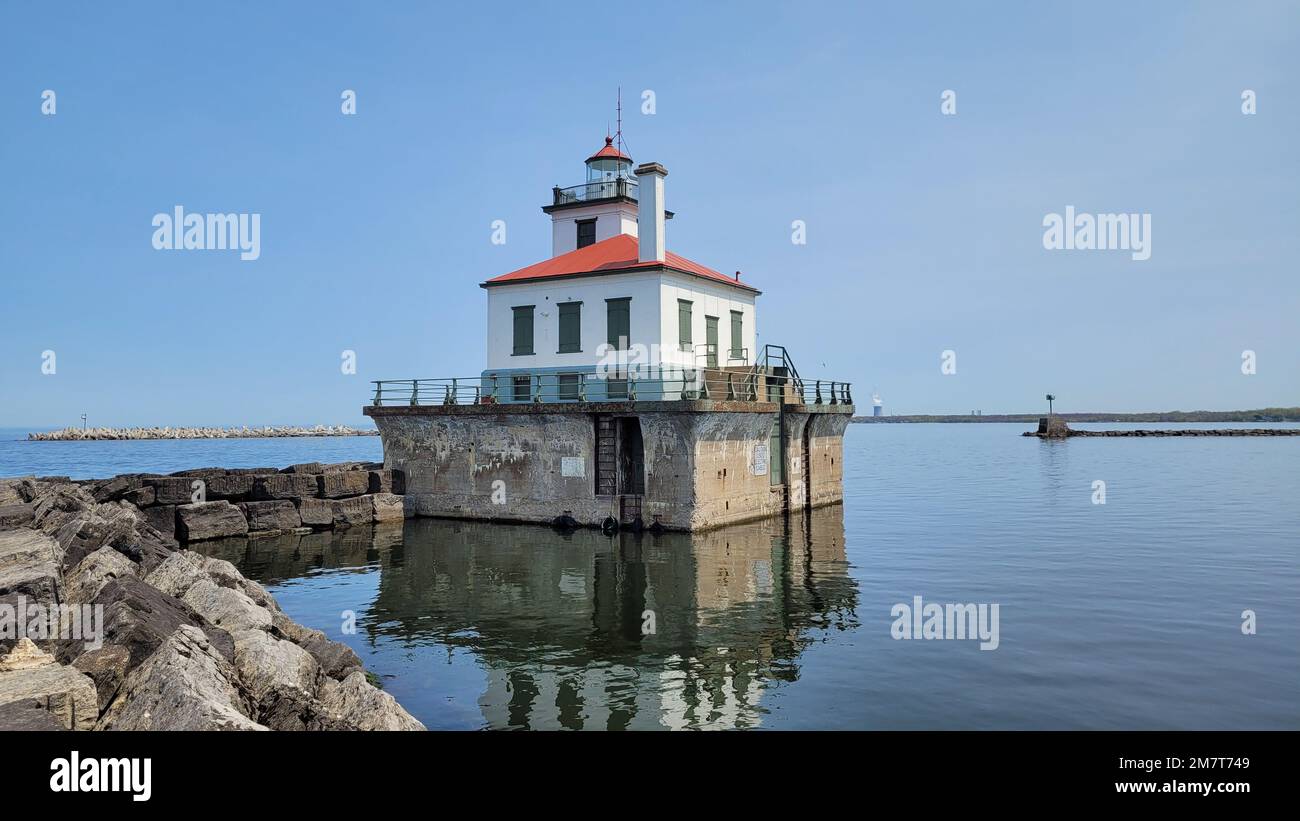 The Oswego Harbor West Pierhead Lighthouse stands as an active aid to navigation at the end of a 2,000-foot-long breakwater located off the coast of Oswego, New York, May 12, 2022. The breakwater, maintained by the U.S. Army Corps of Engineers, Buffalo District, ensures safe navigation for commercial and recreational vessels travelling on the Great Lakes and the Oswego River. Stock Photo