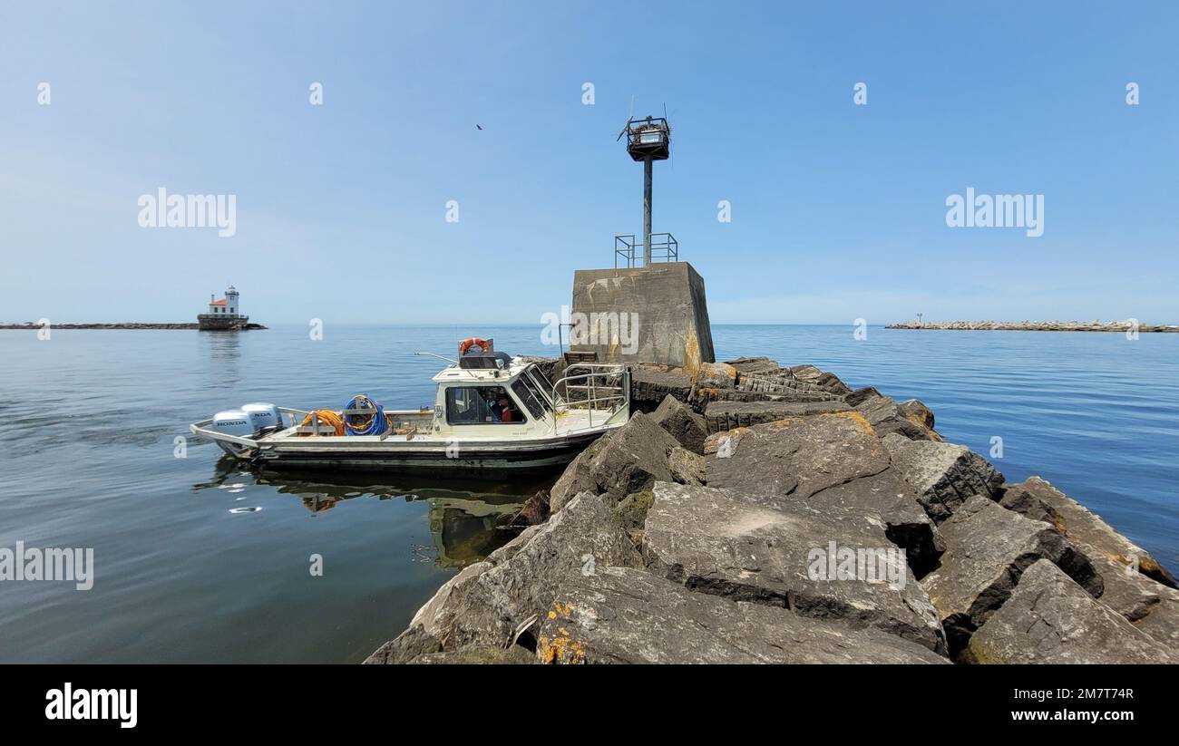 A dive boat operated by the U.S. Army Corps of Engineers, Buffalo District noses up against a breakwater in the harbor of Oswego, New York, May 12, 2022. The vessel carried team members from the district during an inspection of the breakwater, which is maintained to ensure safe navigation for commercial and recreational vessels travelling on the Great Lakes and Oswego River. Stock Photo