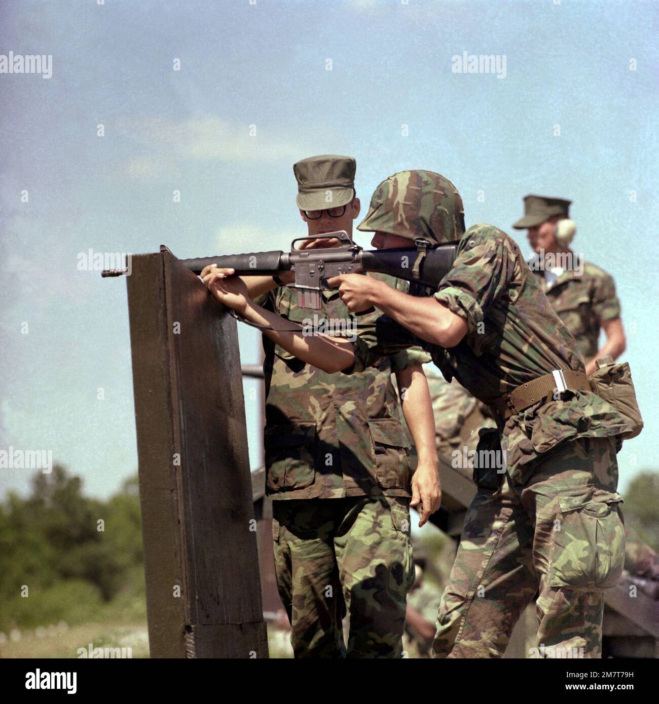 CPL Mike Smith, a rifle marksmanship coach at the Weapons Battalion, observes a 1ST Battalion recruit practicing the over-the-wall shooting position with an M-16A1 rifle. Base: Usmc Recruit Depot,Parris Island State: South Carolina (SC) Country: United States Of America (USA) Stock Photo