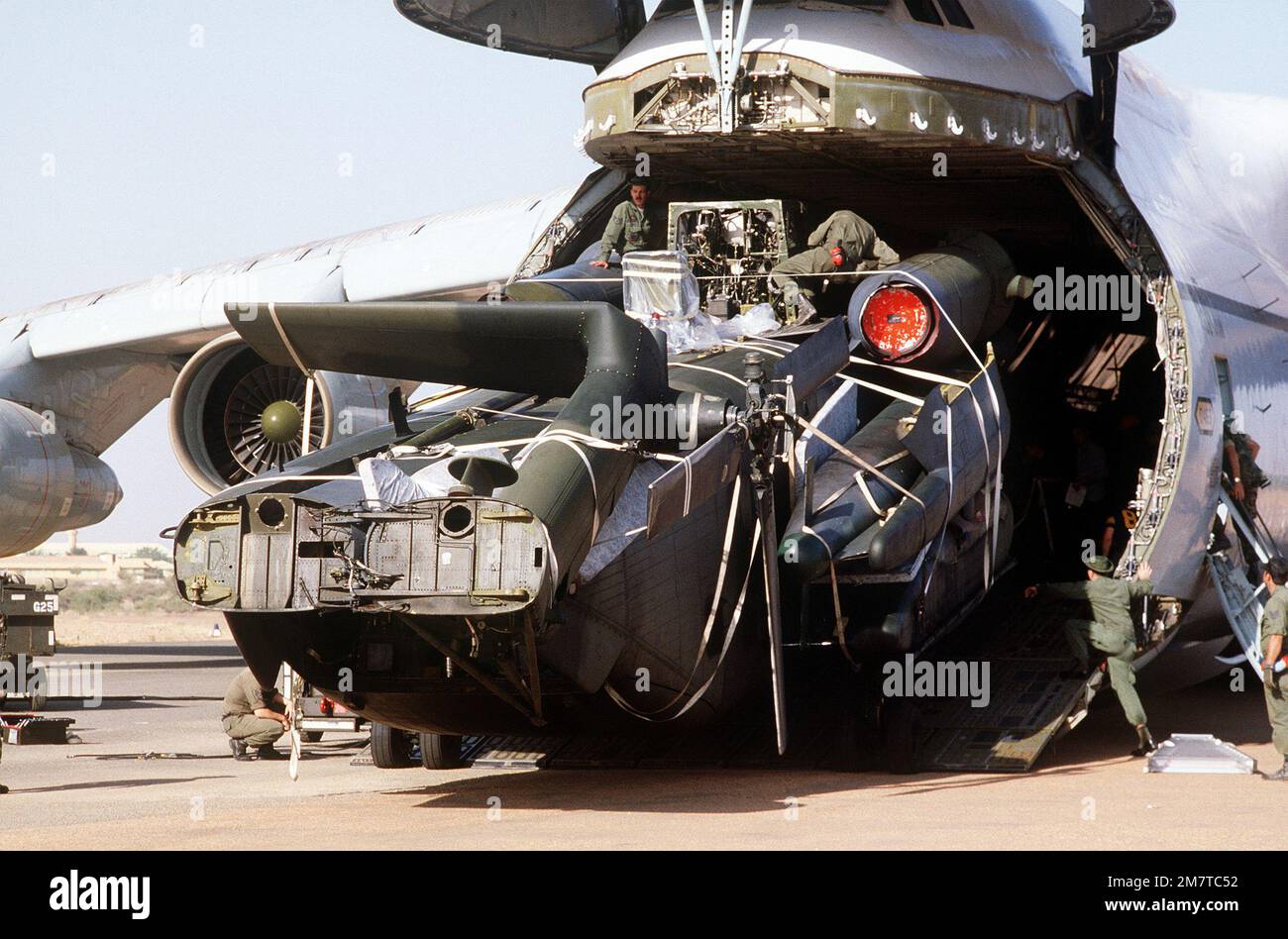 A CH-53 Jolly Green Giant helicopter is unloaded from a C-5 Galaxy