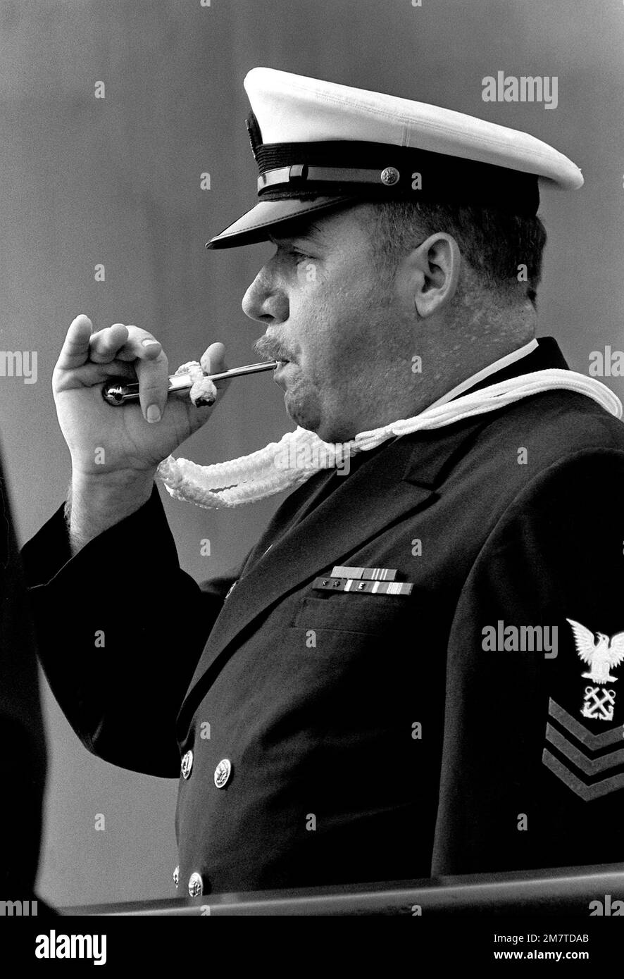 A boatswain's mate 1ST class pipes the first watch during the