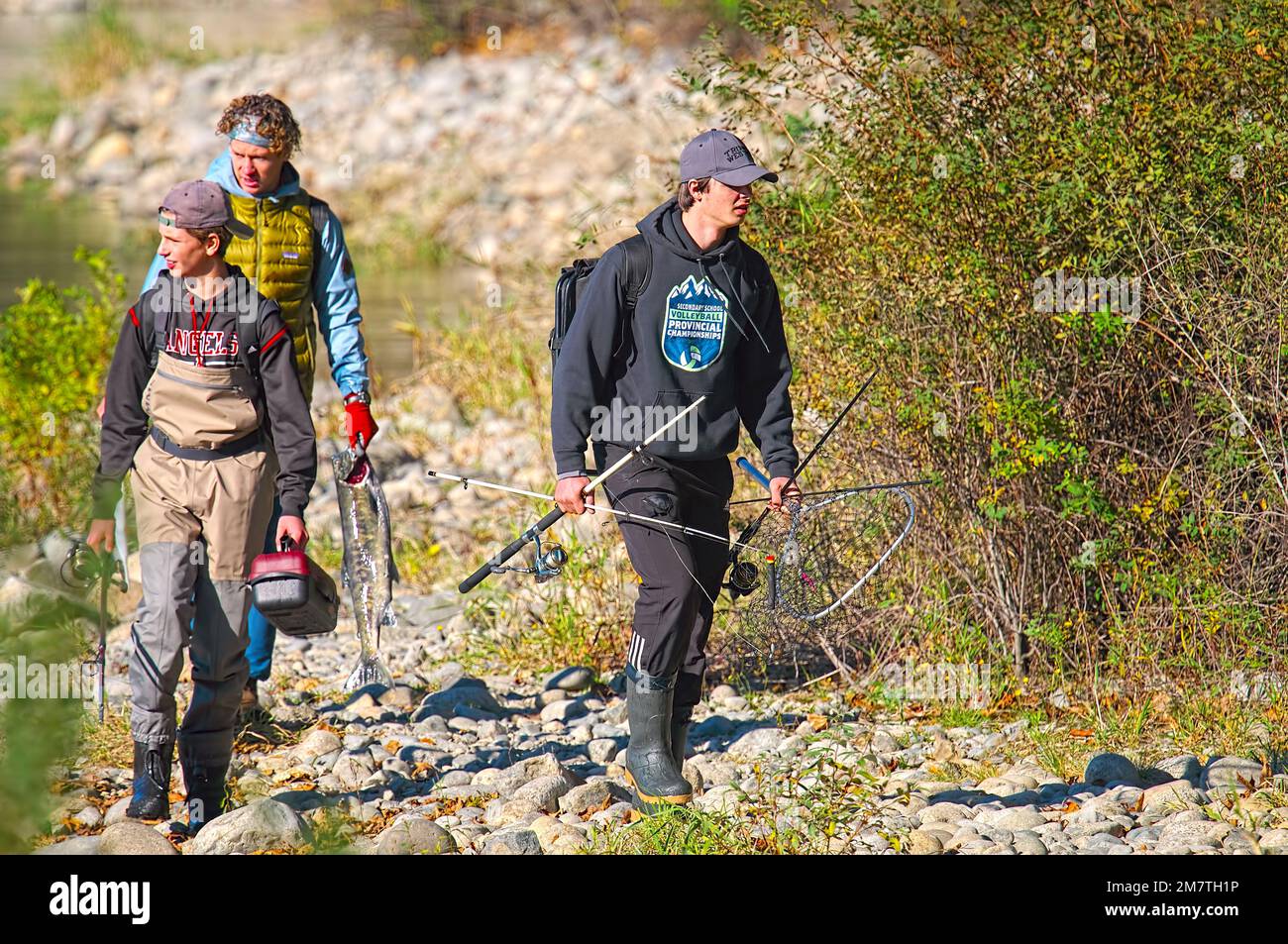 Three young men with fishing gear and a salmon. Metro Vancouver