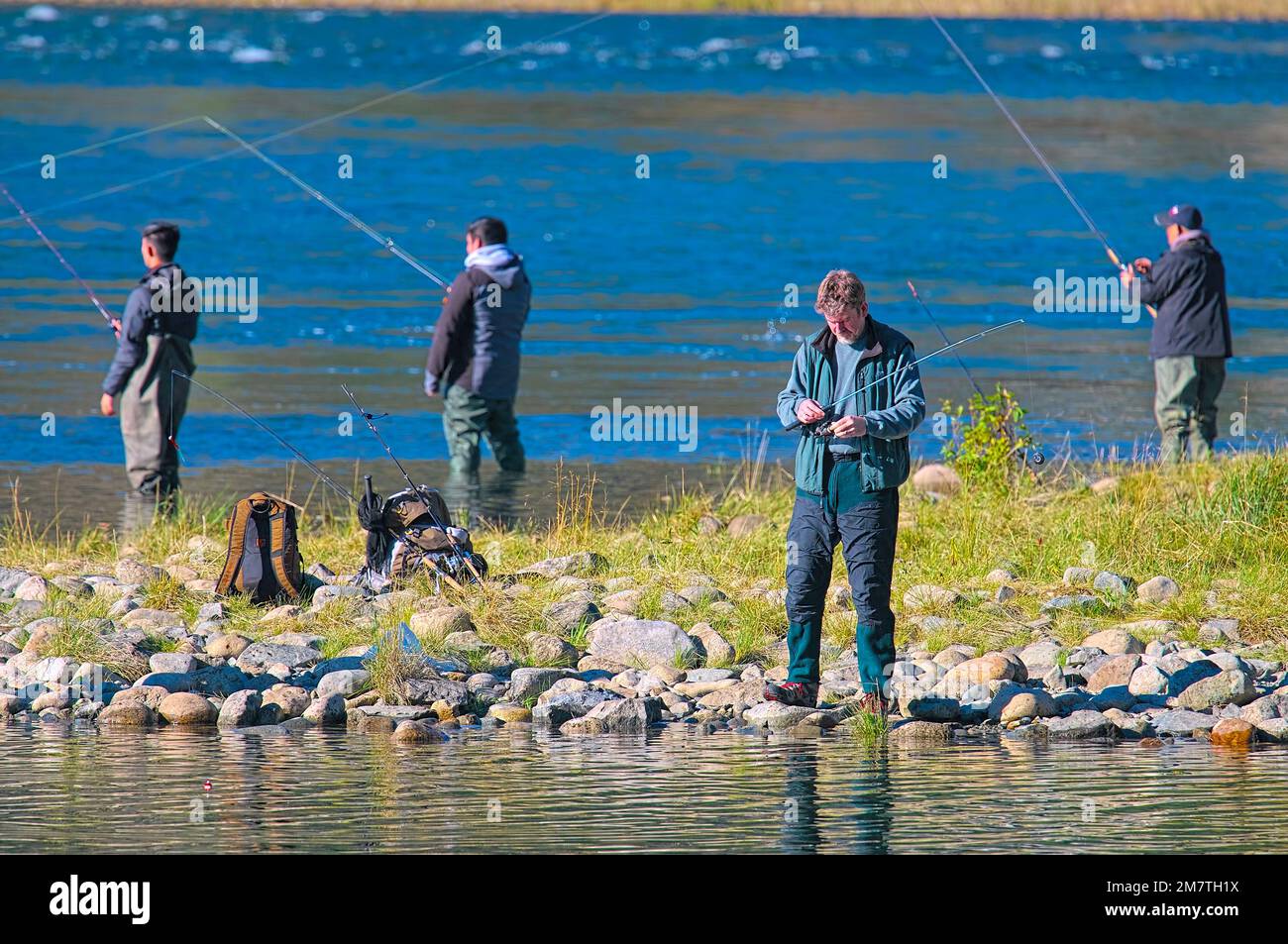 Fishermen with rods cast during a salmon run.  Metro Vancouver, British Columbia, Canada. November 2020. Stock Photo