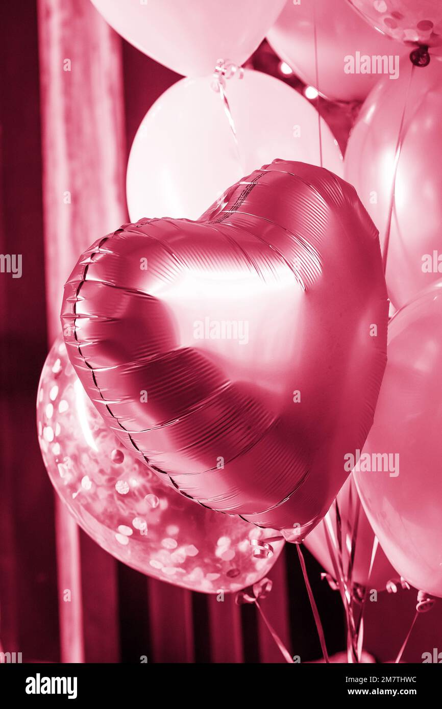Air Balloons of heart shaped foil on blurred background. Love concept. Holiday celebration. Valentine's Day or wedding,bachelorette party decoration Stock Photo