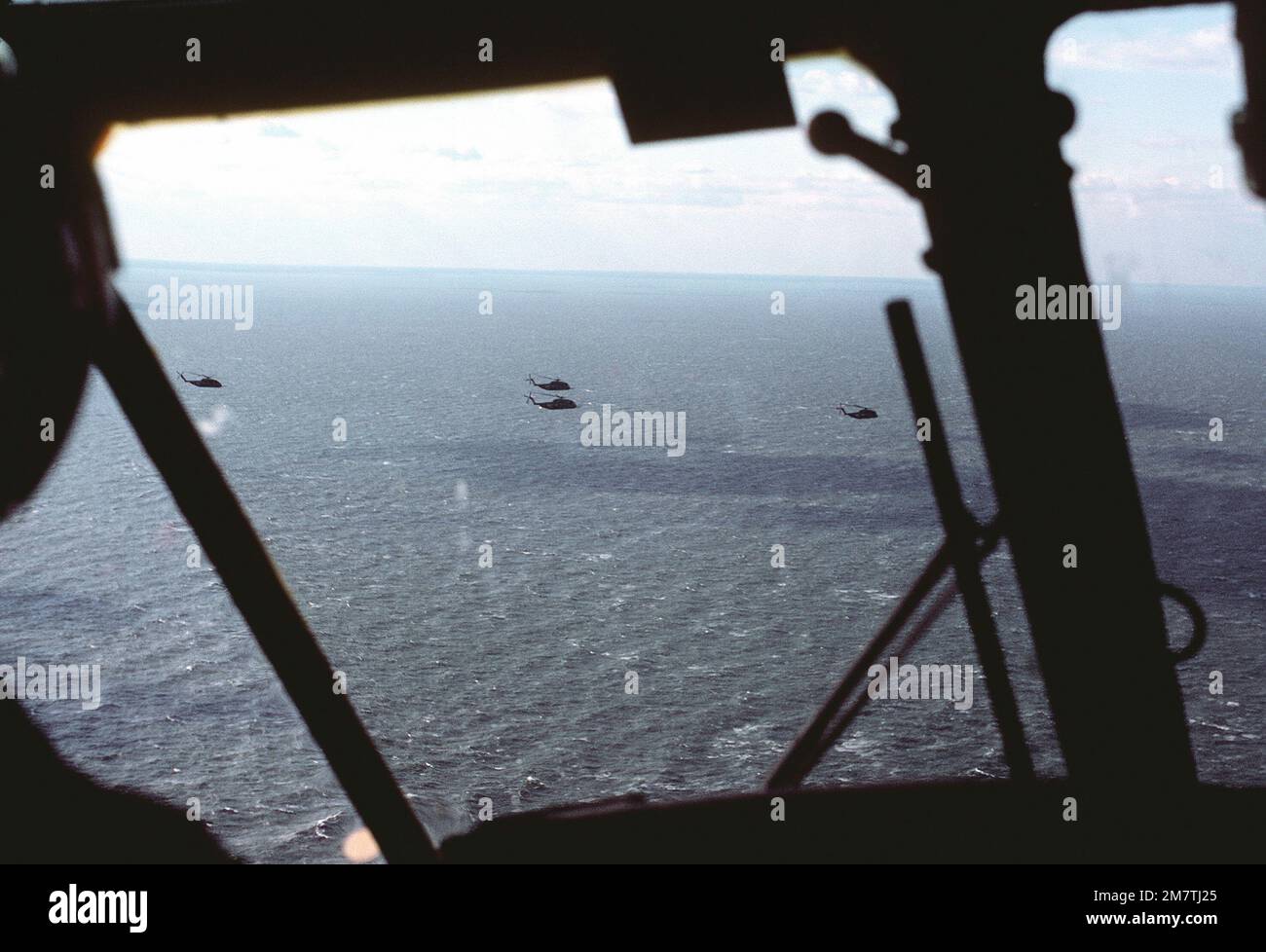 An air-to-air view of four RH-53D Sea Stallion helicopters as seen from the cockpit of an SH-3 Sea King helicopter during search and rescue (SAR) operations. Country: Chesapeake Bay Stock Photo