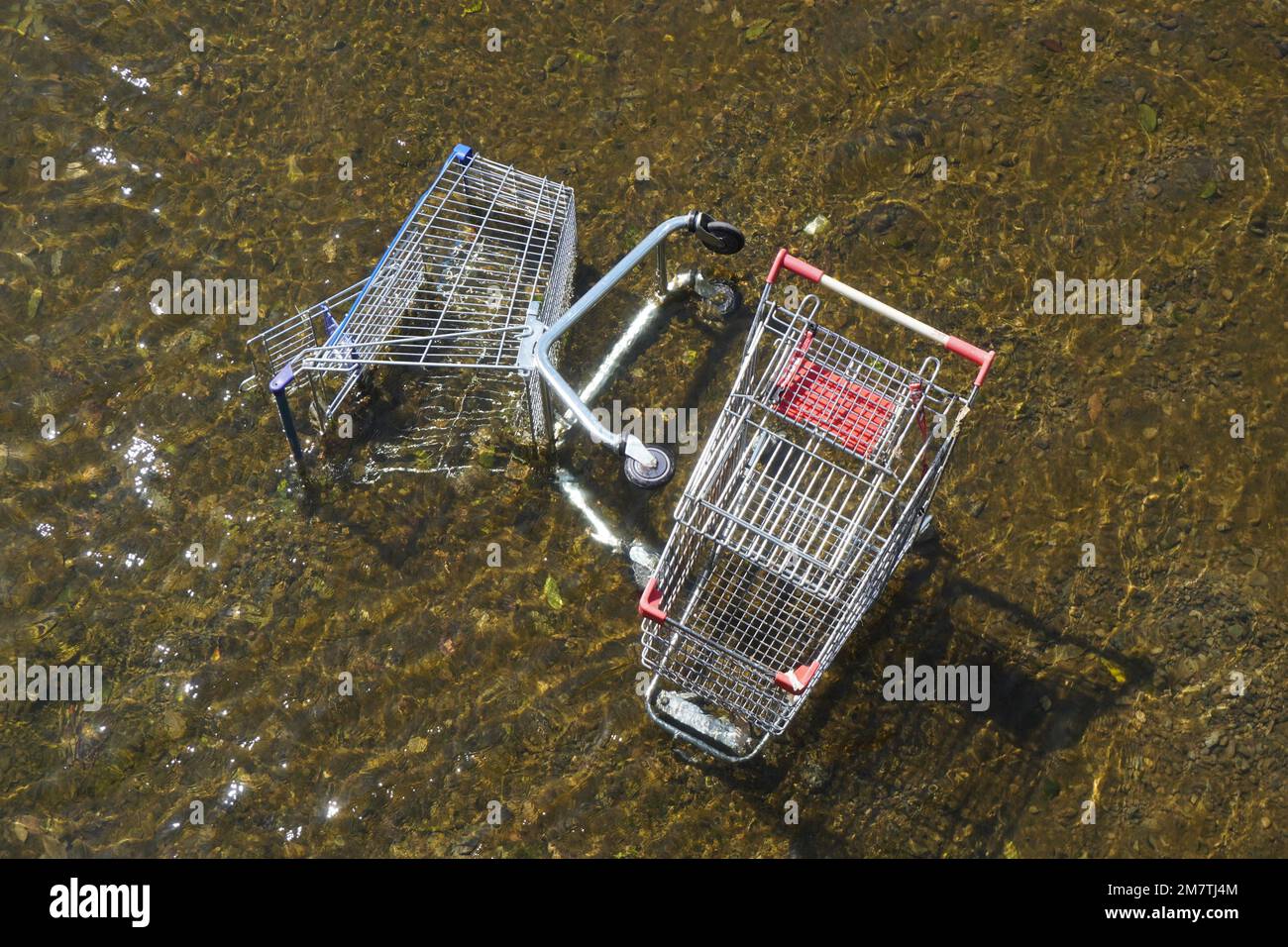 Toppled Shopping Trolleys in Shallow Water Stock Photo
