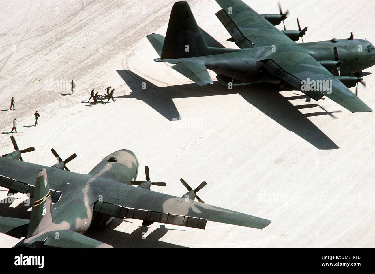 Crew members carry a "casualty" to a C130 Hercules aircraft from an