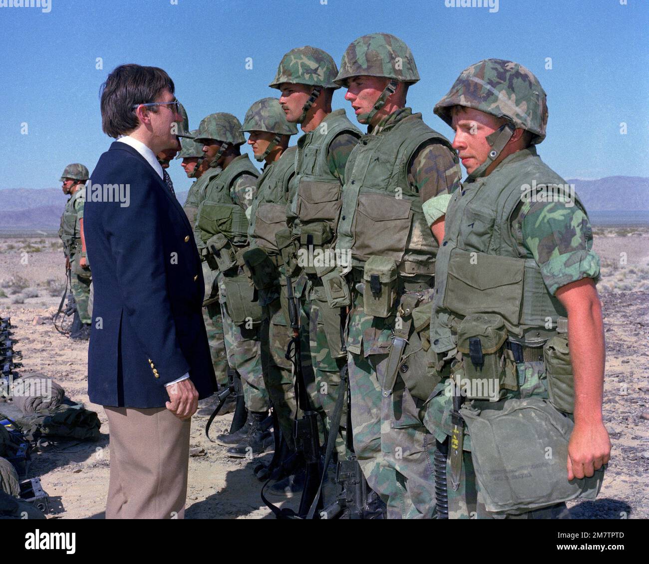 Secretary of the Navy John Lehman Jr. talks to a squad of Marines who are participating in a CAX operation at the Marine Corps Air-Ground Combat Center. The secretary is touring military installations. Base: Twentynine Palms State: California (CA) Country: United States Of America (USA) Stock Photo