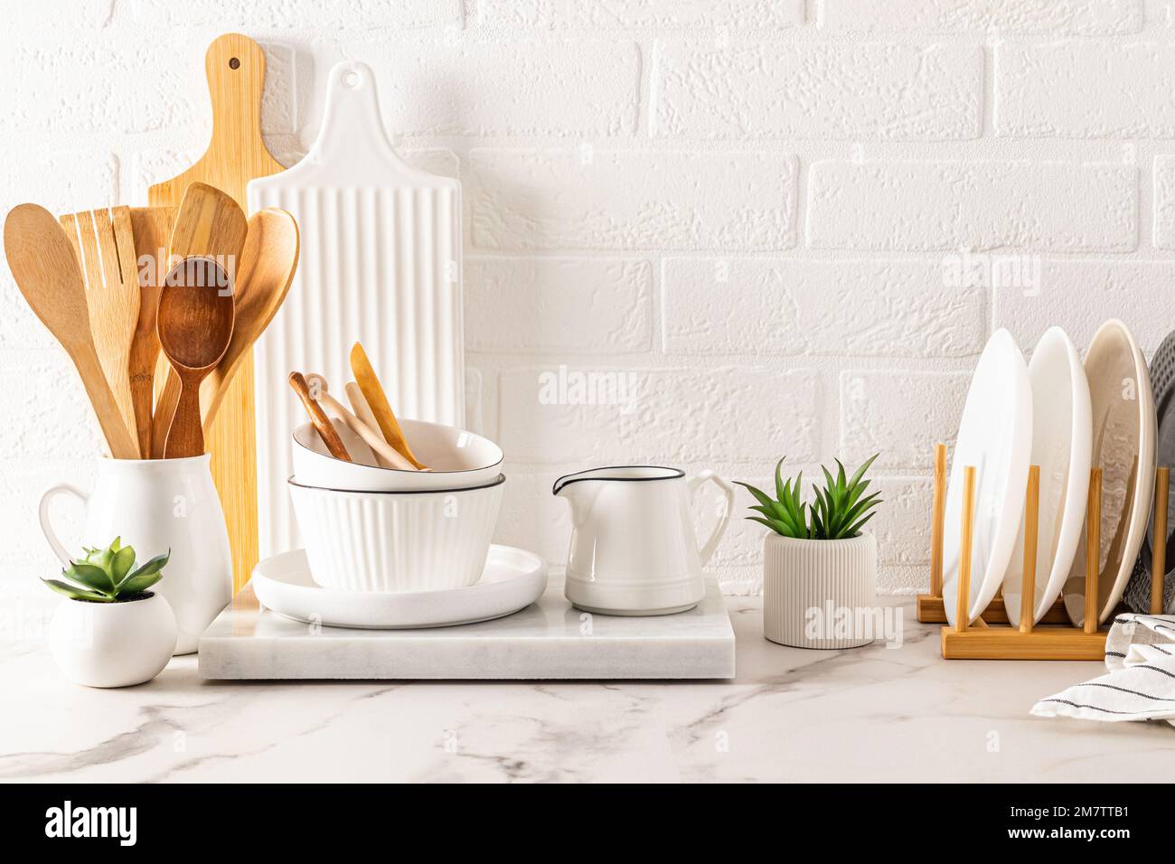 White ceramic utensils and kitchen utensils on a wooden countertop