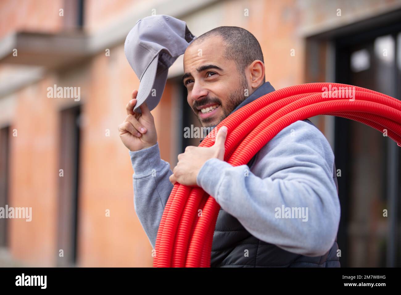 portrait of plumber with red pipes on construction site Stock Photo
