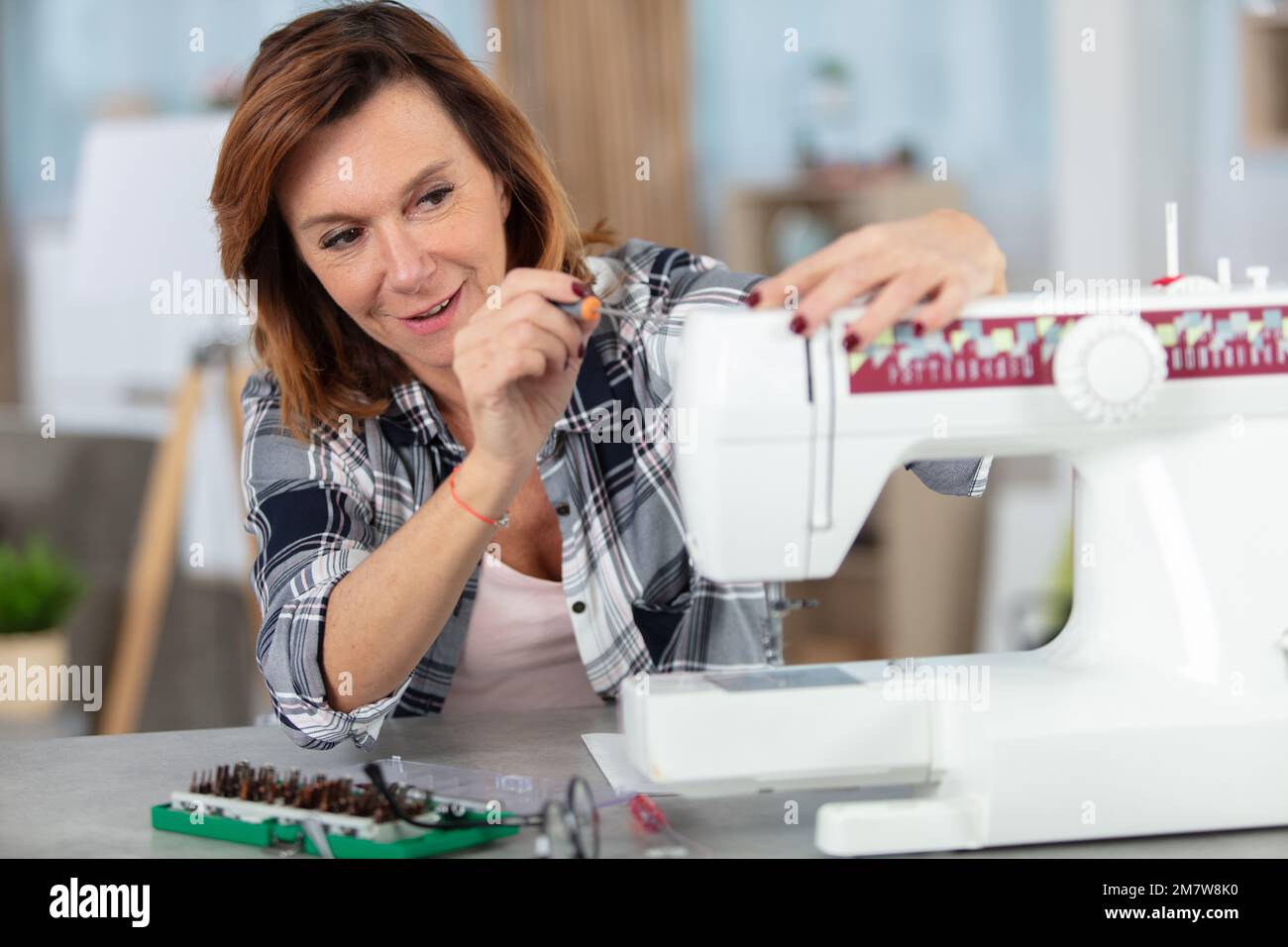 mature woman repairing sewing machine Stock Photo Alamy