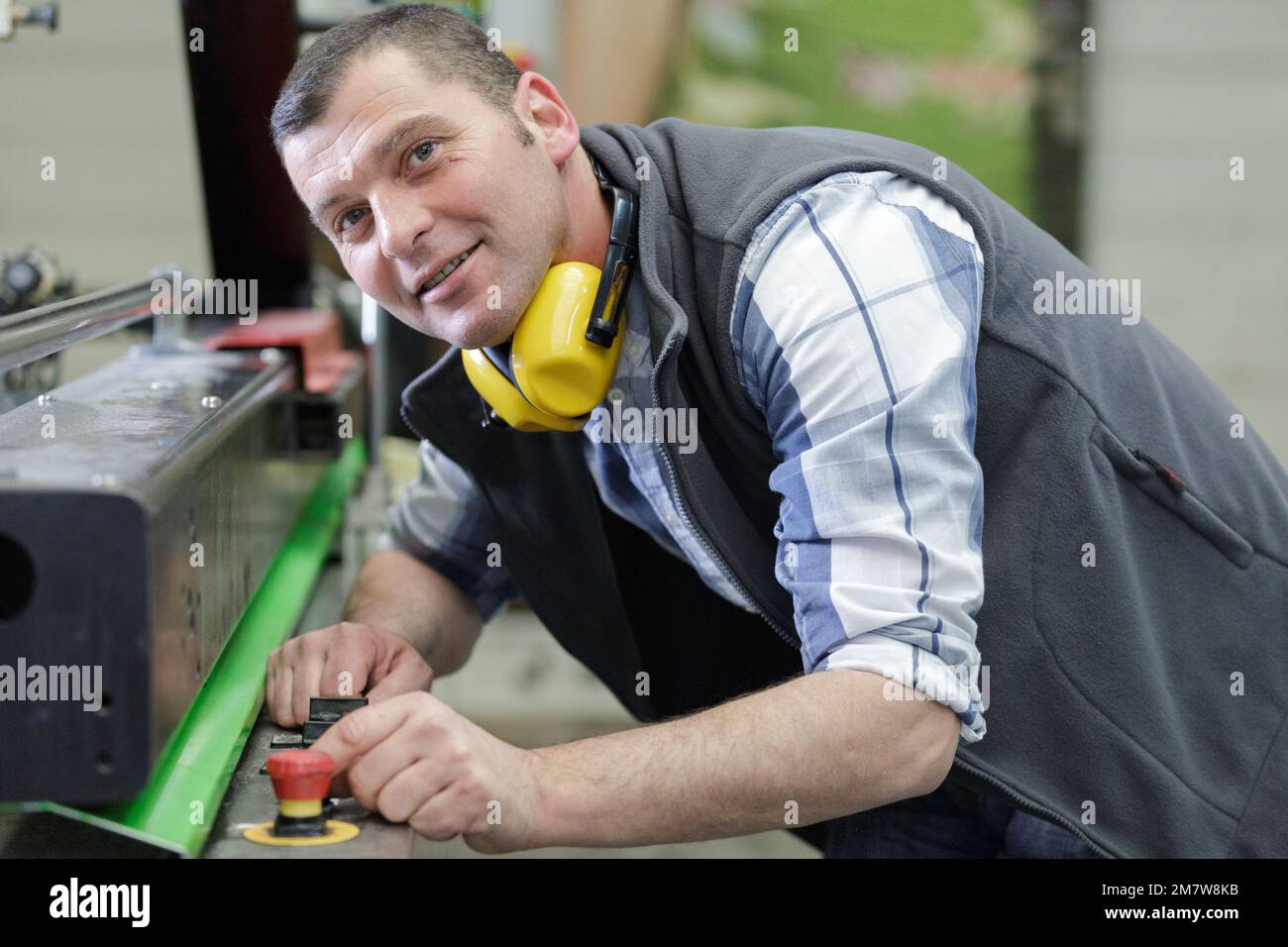 portrait of mature factory worker smiling at camera Stock Photo