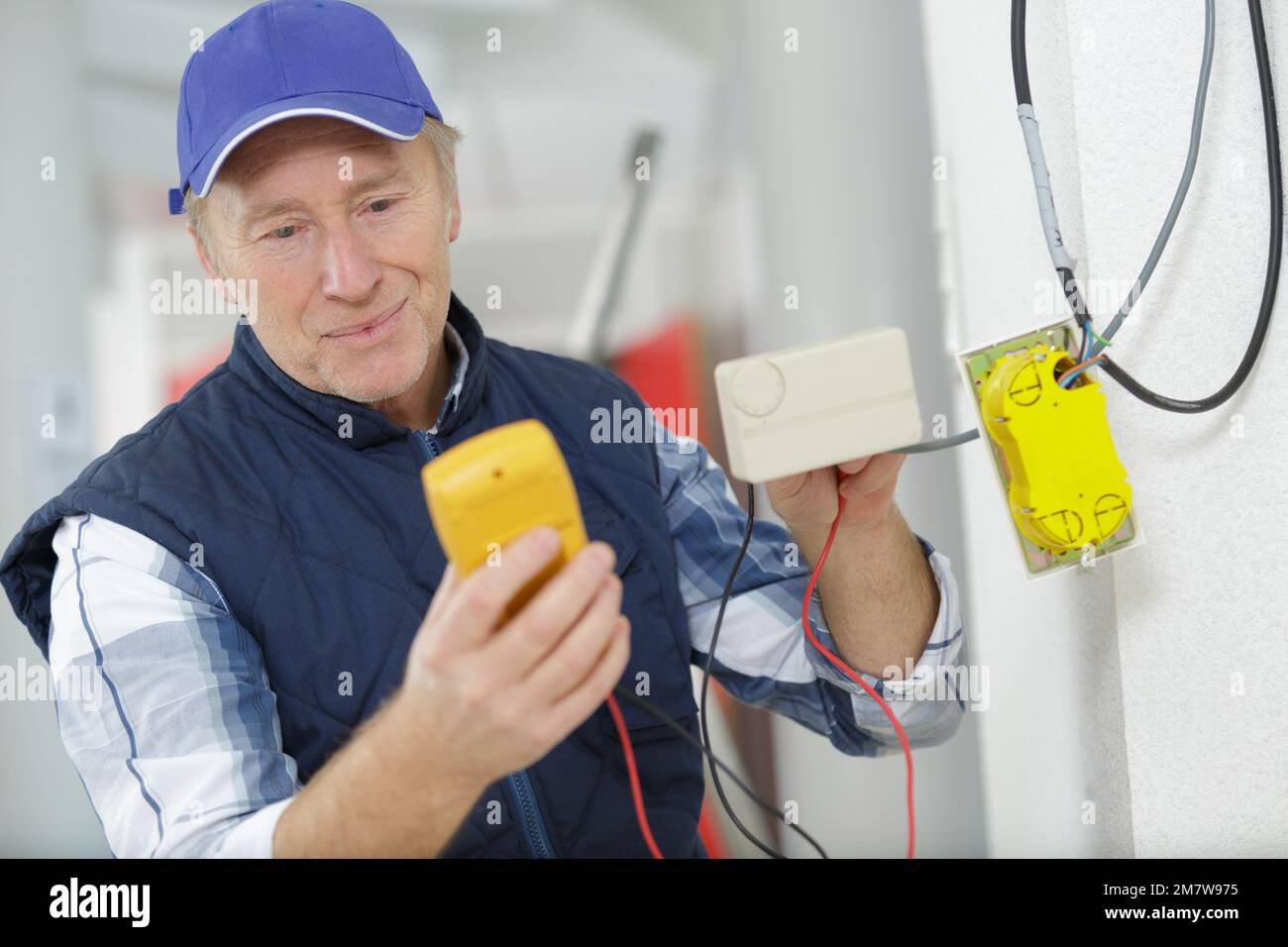 experienced electrician doing electrical work Stock Photo