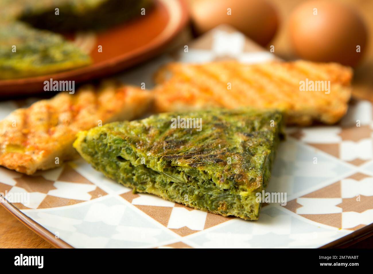 Green asparagus potato omelette. The potato omelette, or Spanish omelette is an omelette or omelette to which chopped potatoes are added. Stock Photo