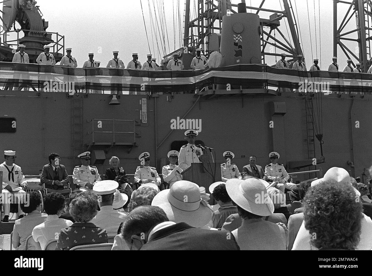 The crew mans the rails of the guided missile frigate USS LEWIS B. PULLER (FFG-23) in the background. CDR Ralph K. Martin speaks to the crowd during the commissioning ceremony for the ship. Base: Naval Air Station, Long Beach State: California (CA) Country: United States Of America (USA) Stock Photo