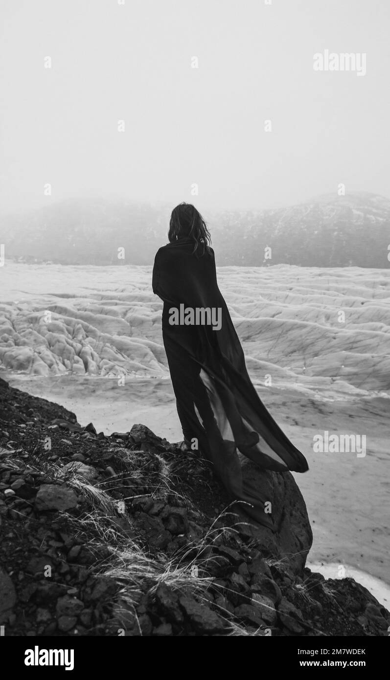 Woman with cape of chiffon on rock monochrome scenic photography Stock Photo