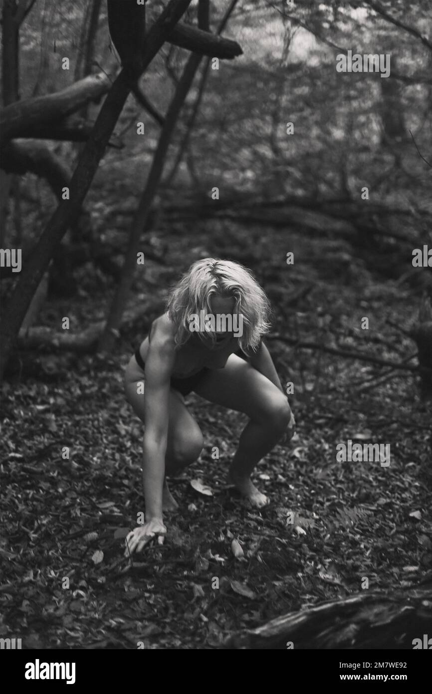 Naked woman sitting on ground in wood monochrome scenic photography Stock  Photo - Alamy