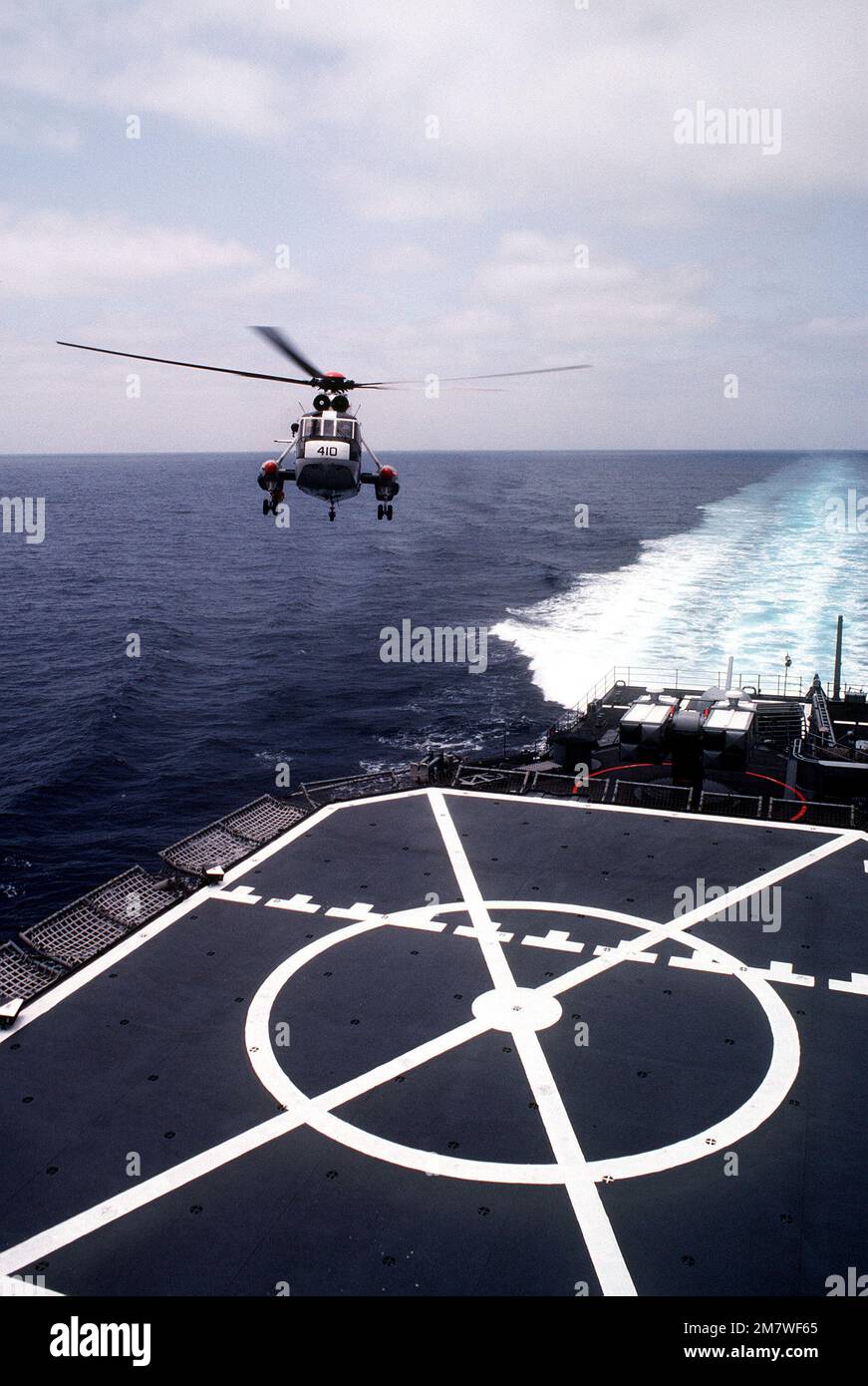 A SH-3 Sea King helicopter approaches the flight deck of the Spruance class destroyer USS INGERSOLL (DD-990), during at-sea landing qualifications for Reserve Helicopter Anti-submarine Squadron 84 (HS-84). Country: Pacific Ocean (POC) Stock Photo
