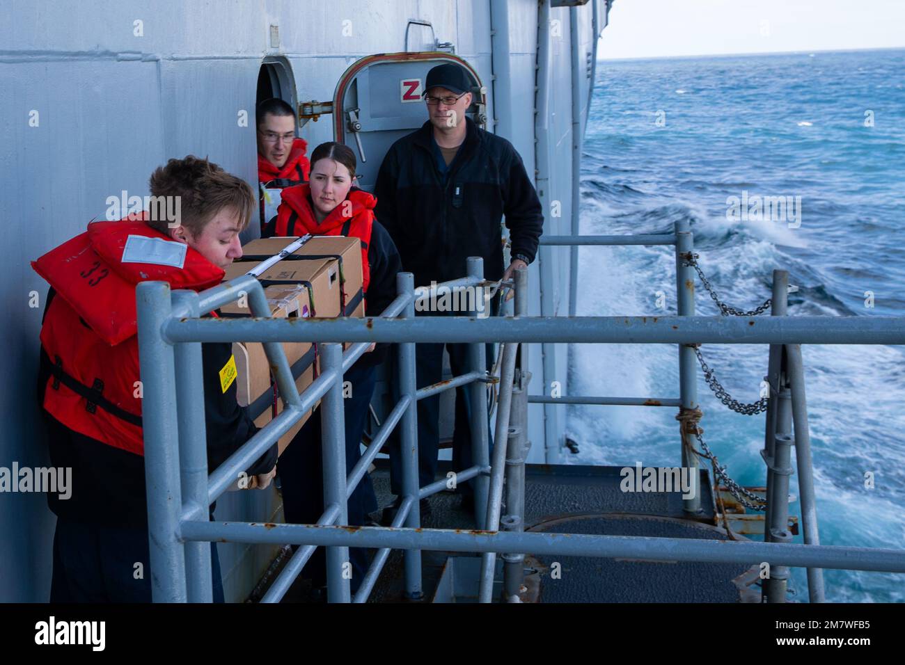 220515-N-CM110-1027 PACIFIC OCEAN (May 15, 2022) – Aerographer’s Mate 3rd Class Chase Mischka, from Santee, California, left, and Aerographer’s Mate 1st Class Ashley Mccown, from El Paso, Texas, carry a buoy aboard amphibious assault carrier USS Tripoli (LHA 7), May 15, 2022. Tripoli is underway conducting routine operations in U.S. 7th Fleet. Stock Photo