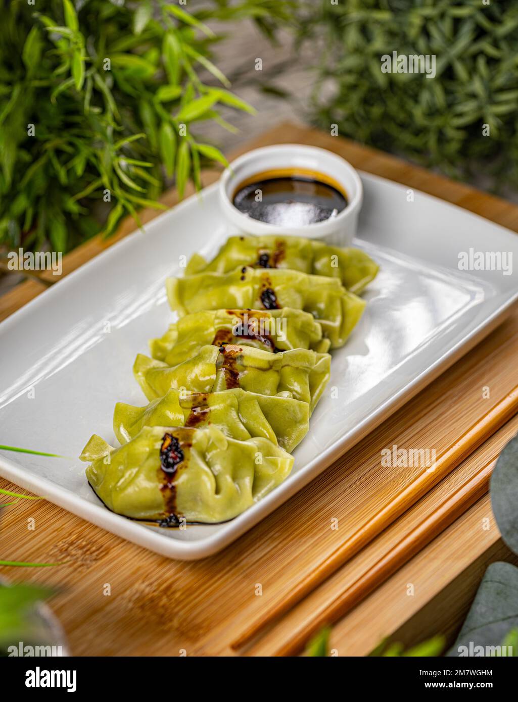 Platter of steamed Chinese spinach filling dumplings served with soy sauce Stock Photo