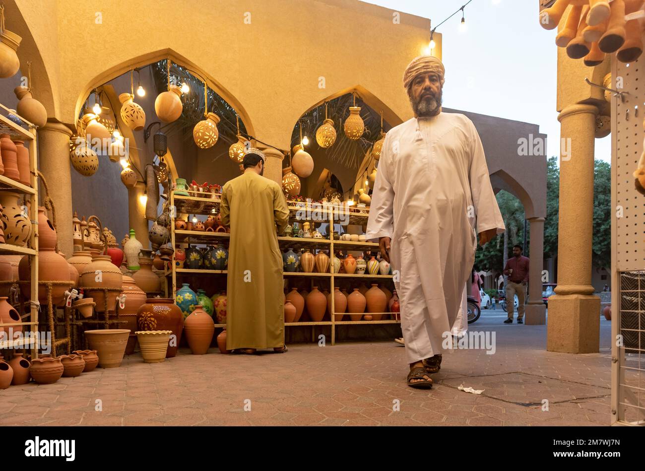 Omani man in traditional dishdasha dress walks through Nizwa Souq, Oman Stock Photo